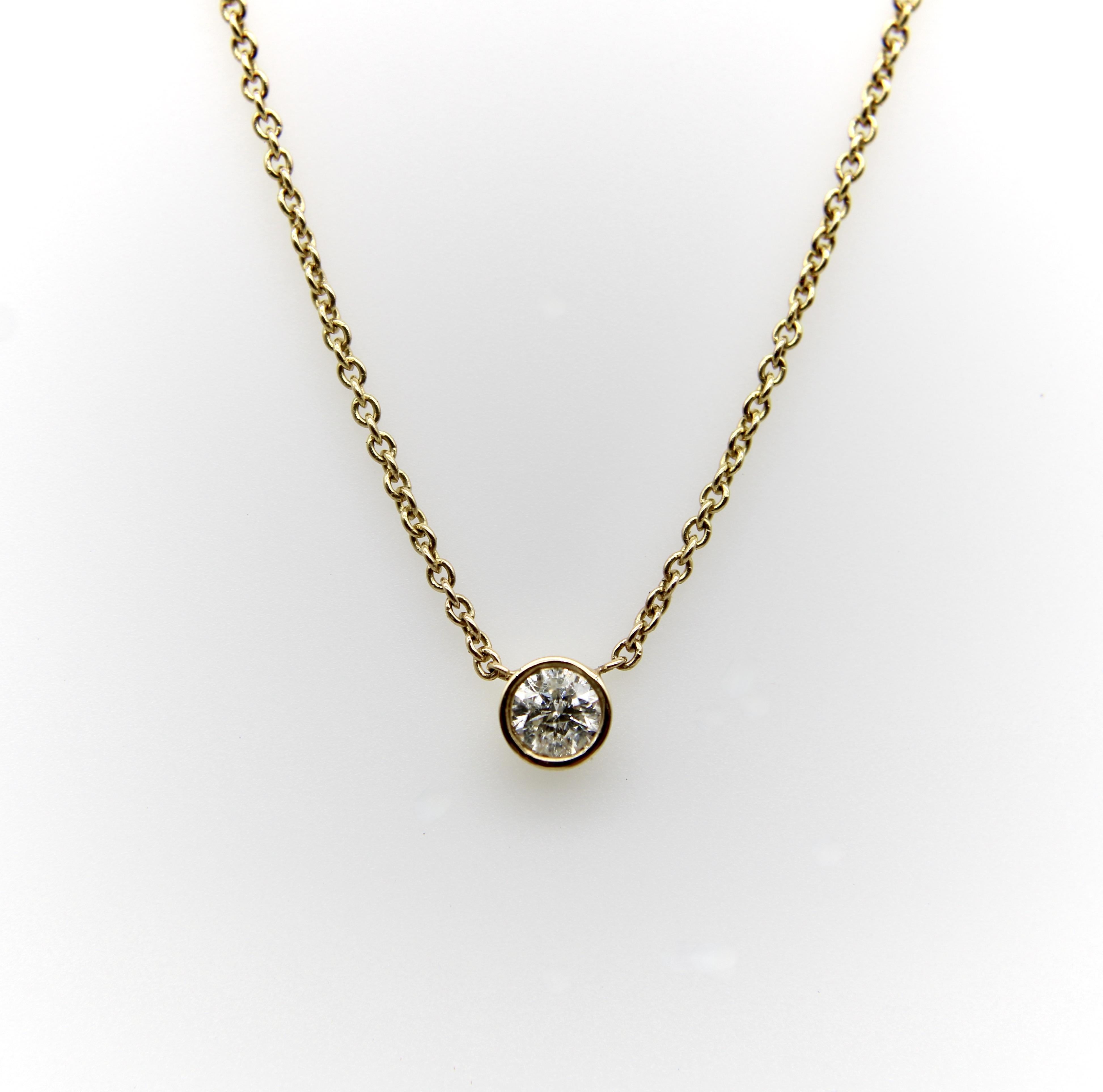 Diese zarte Halskette aus 14-karätigem Gold ist mit einem eingefassten Diamanten versehen, der an einer feinen Goldkette hängt. Sie ist anmutig und feminin, verleiht dem Dekolleté einen schlichten Glanz und eignet sich perfekt zum Kombinieren mit