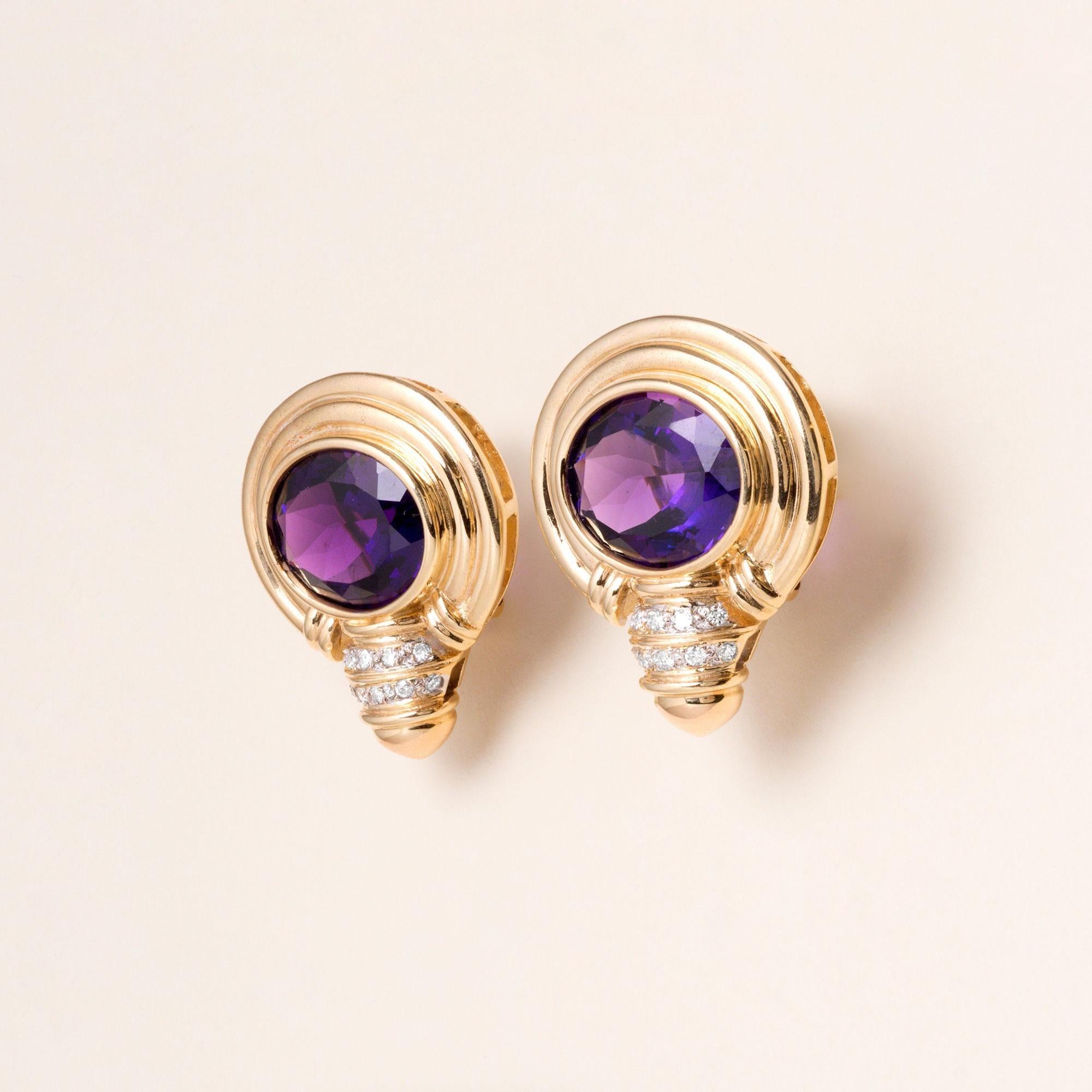 Questi eleganti orecchini vintage catturano la sofisticatezza senza sforzo dello stile francese degli anni '90. Realizzati in ricco oro giallo 14 carati, presentano ametiste viola intenso splendidamente saturate, incastonate in un'audace montatura
