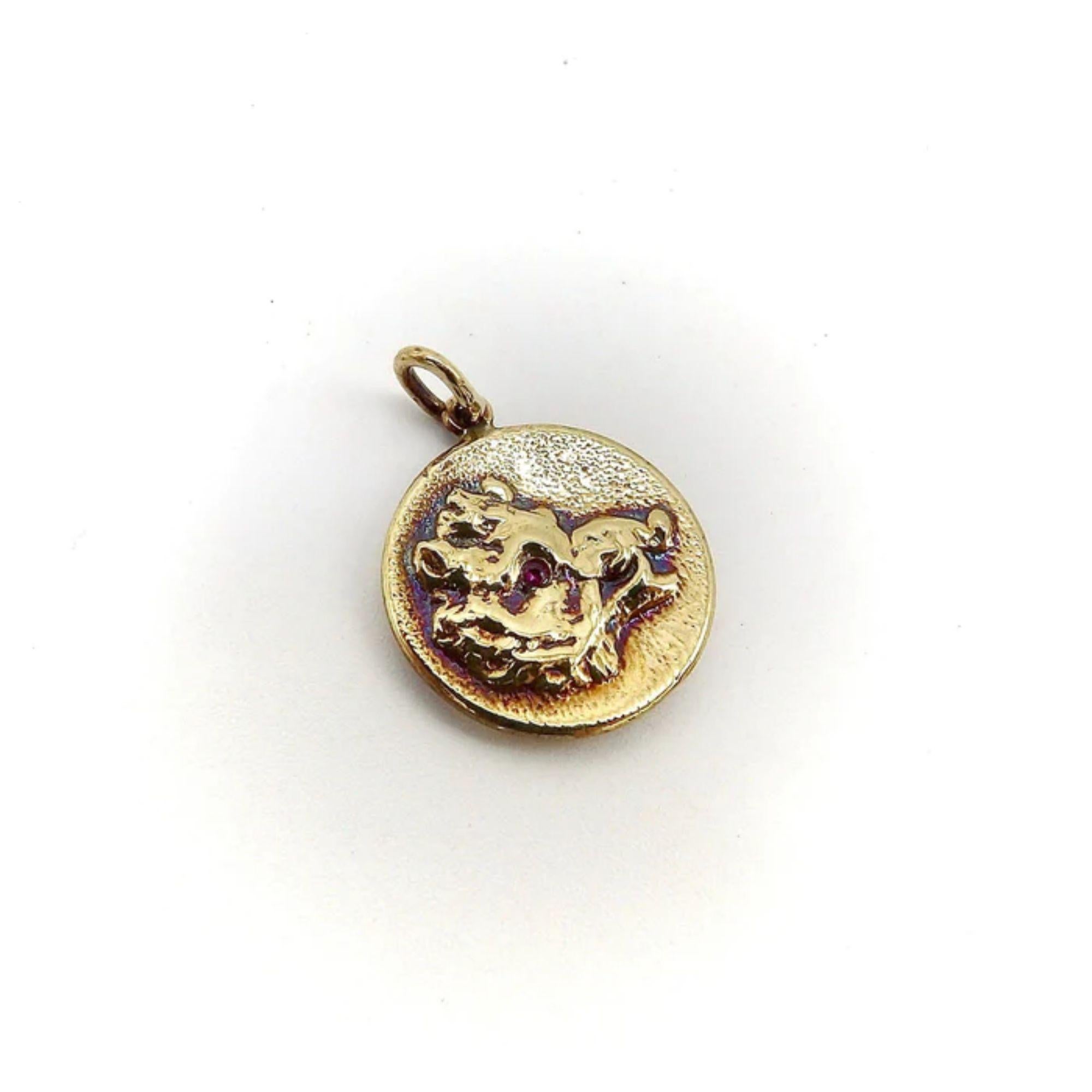 This is a precious 14k gold medallion charm from Kirsten’s Corner signature “Cute as a Button” collection. It is handcrafted from a Victorian era button and features a portrait of a boar. The face of the boar has striking ruby eyes that offer a nice