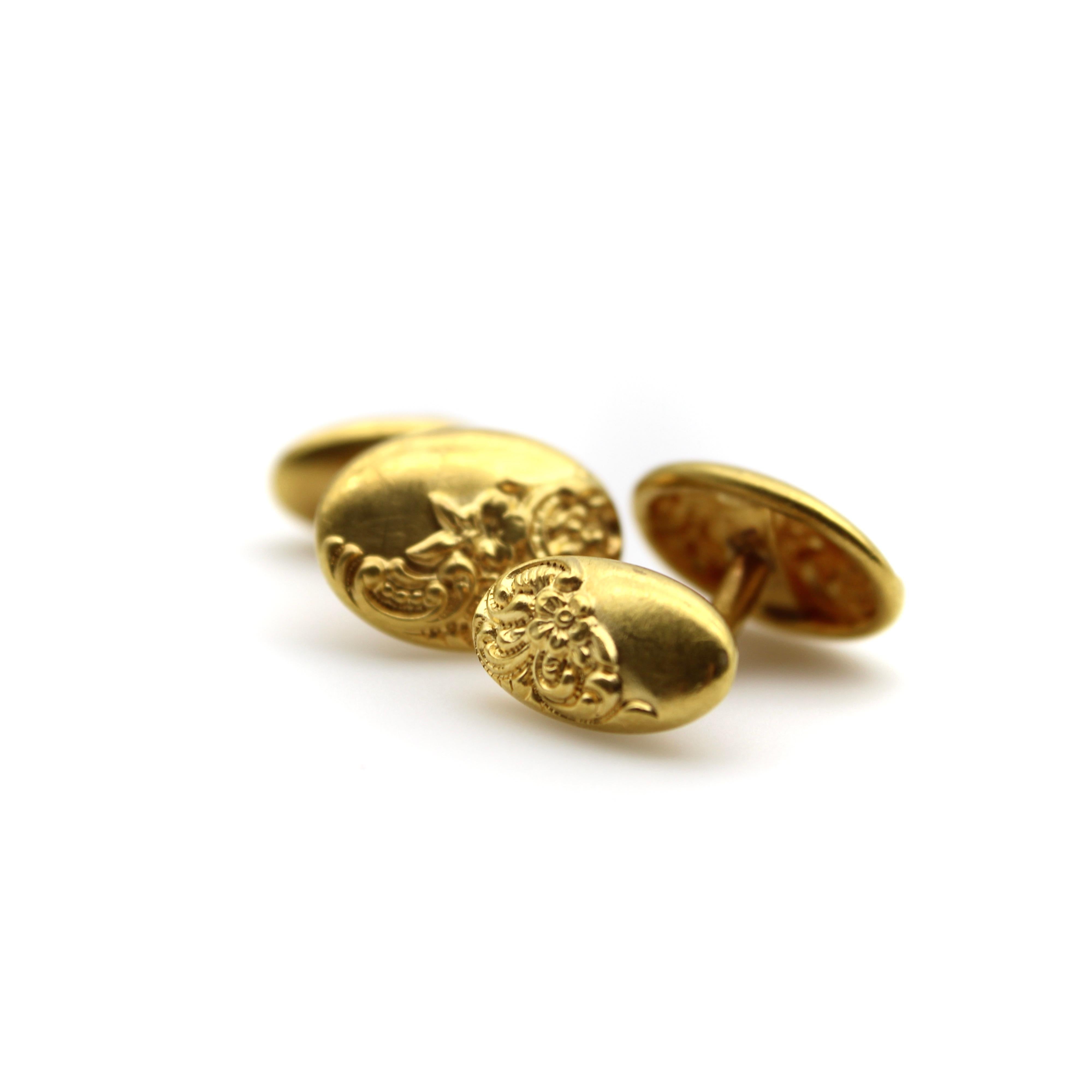 These Victorian cufflinks are graceful and elegant; a repousse design covers the oval shapes with a sweeping floral pattern halfway across the links, while the other half is a beautiful matte surface. The cufflinks are 14k gold, but are bloomed in
