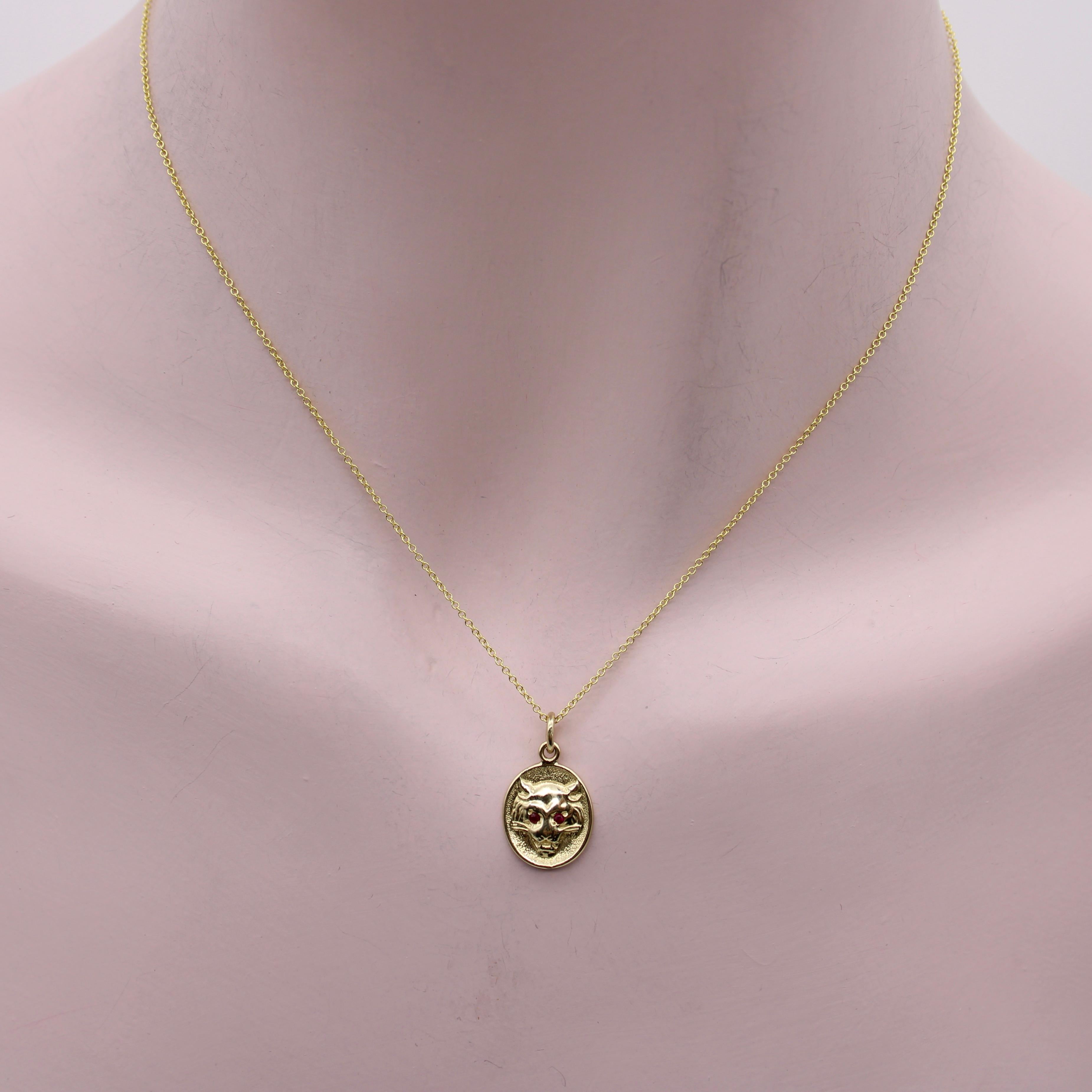 This 14K gold Victorian inspired pendant or charm features a striking bas-relief of a lioness' head with ruby eyes. This Signature piece is part of our Cute-As-A-Button collection. It's been carefully molded from Victorian era cufflinks and is now