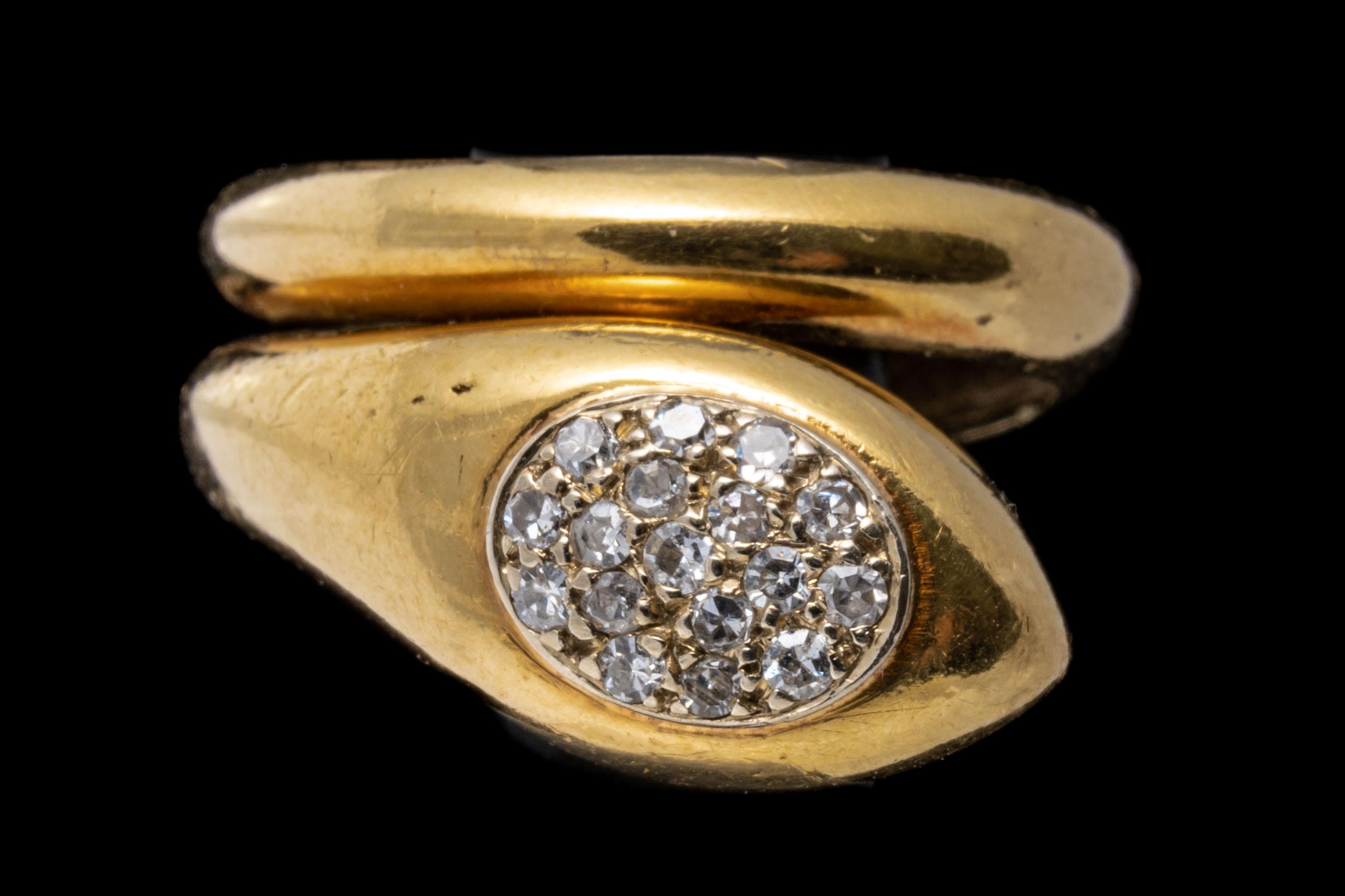 14k yellow gold ring. This contemporary ring is a coiled snake motif with a high polished body, wound into a single coil and finished with an oval cluster of pave set, round faceted diamonds, set into the top of the head, approximately 0.08