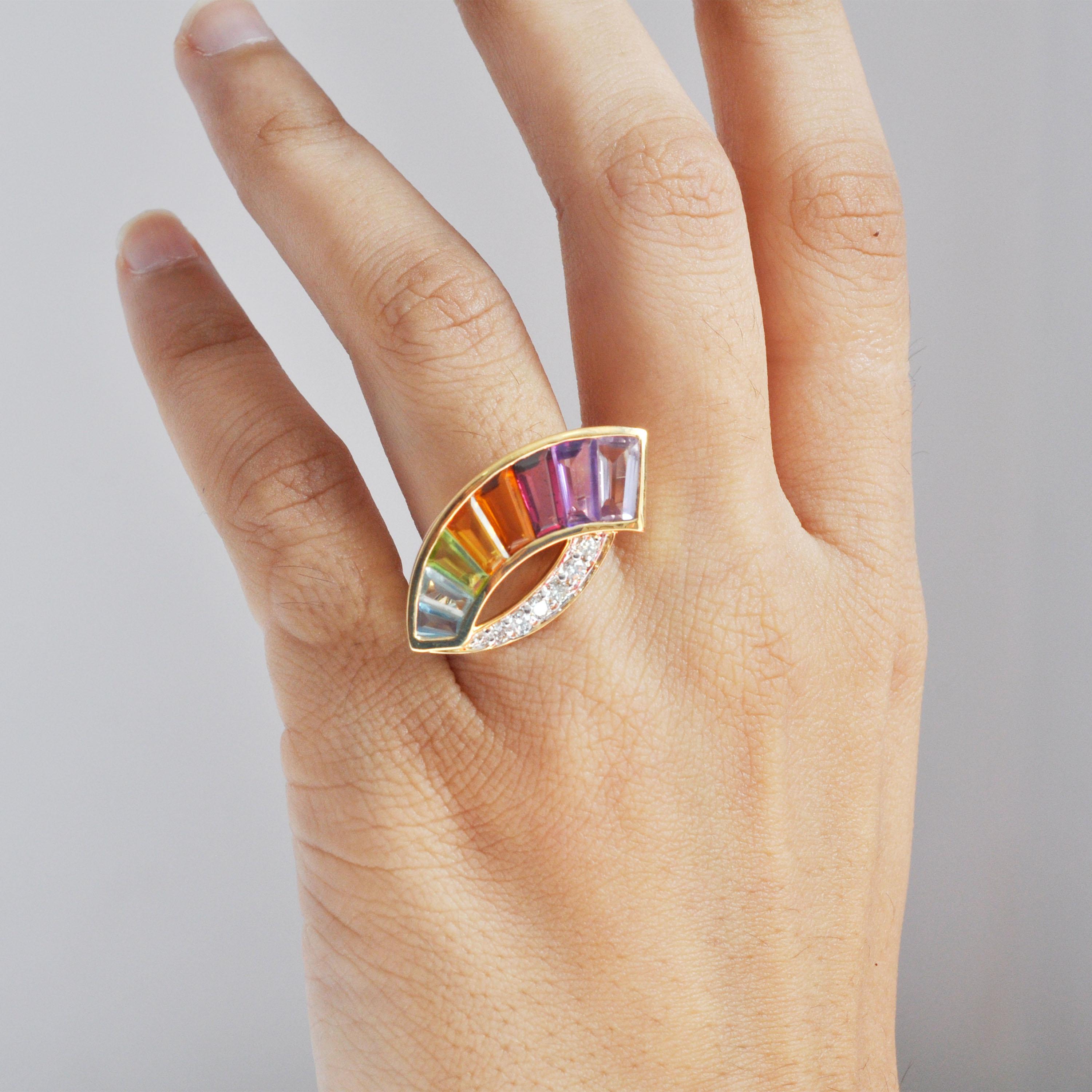 Dieser exquisite Ring aus 14 Karat Gold ist eine schillernde Verschmelzung von Farbe, Handwerkskunst und zeitgenössischem Design. Auf einem schlanken, sichelförmigen Band aus strahlendem 14-karätigem Gelbgold präsentiert der Ring ein atemberaubendes