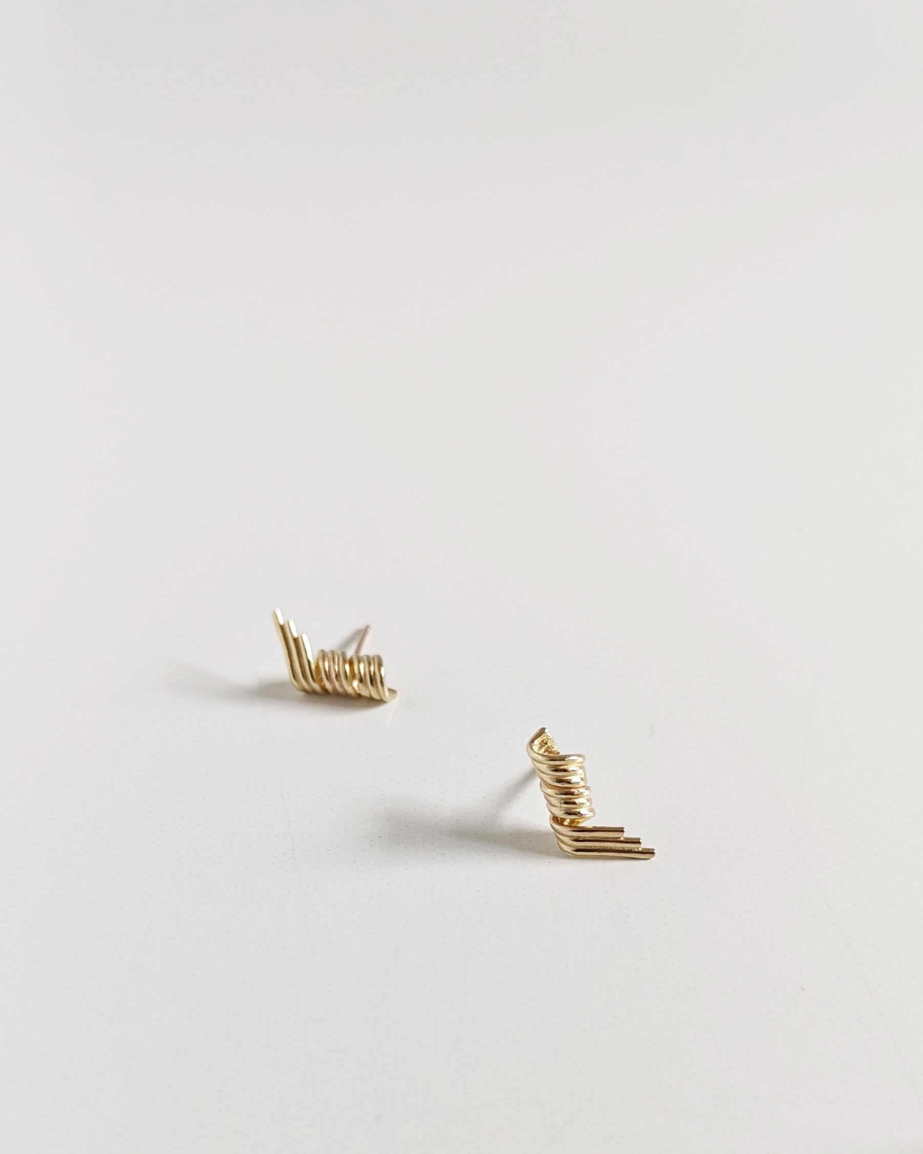 A three-dimensional twist to bar studs… The satisfying curves of spiraling loops rolled into a tubular bar add a unique twist and energy. The corkscrew-style earrings add finesse and effortlessly elevate your outfit.