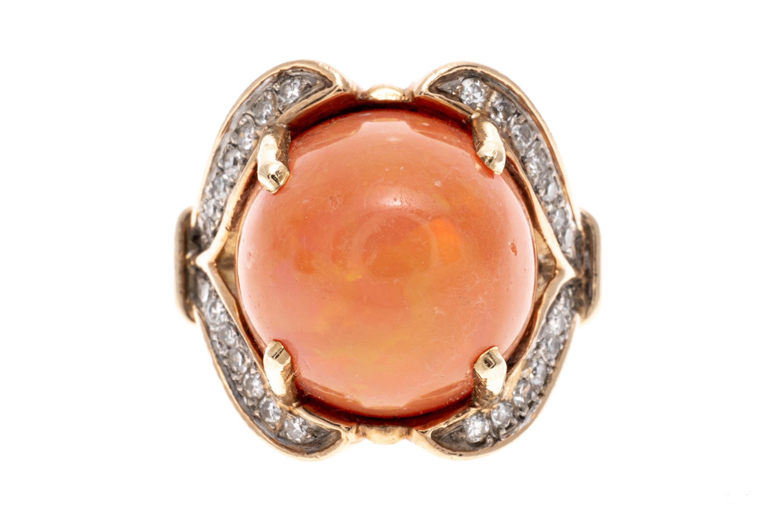 14k yellow gold ring. This stunning ring contains a large center fire opal, a round ball in shape and medium orange with flashes of green color, approximately 10.9 CTS and prong set. Flanking the center is a pretty swirl, set with round, faceted