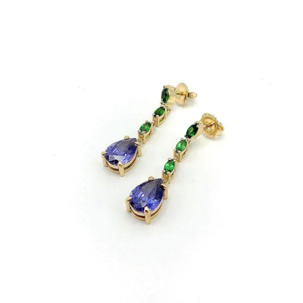 This is a refreshing pair of 14 karat gold Tanzanite and Tsavorite Garnet earrings from Kirsten's Corner signature collection. These post earrings have three marquis shaped beautifully saturated tsavorite garnets that hang in a chain like fashion.