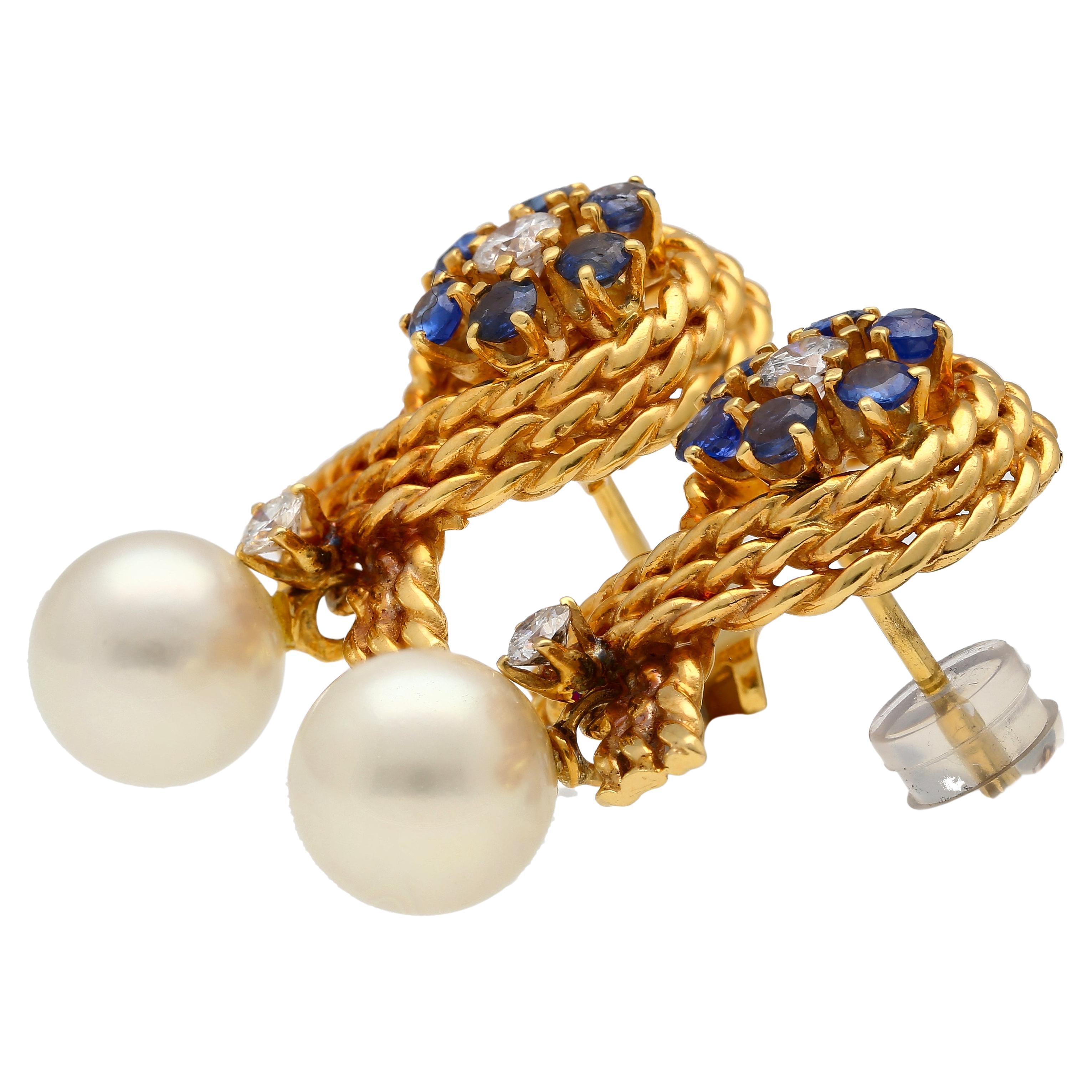 14K solid gold textured ribbon motif stud earrings. Set with a cultured white pearl, round-cut diamonds, and round-cut blue sapphires. Complete with a secure push back closure.

Item Details:
- Type: Earring
- Metal: 14K Solid Gold
- Weight: 7.04
