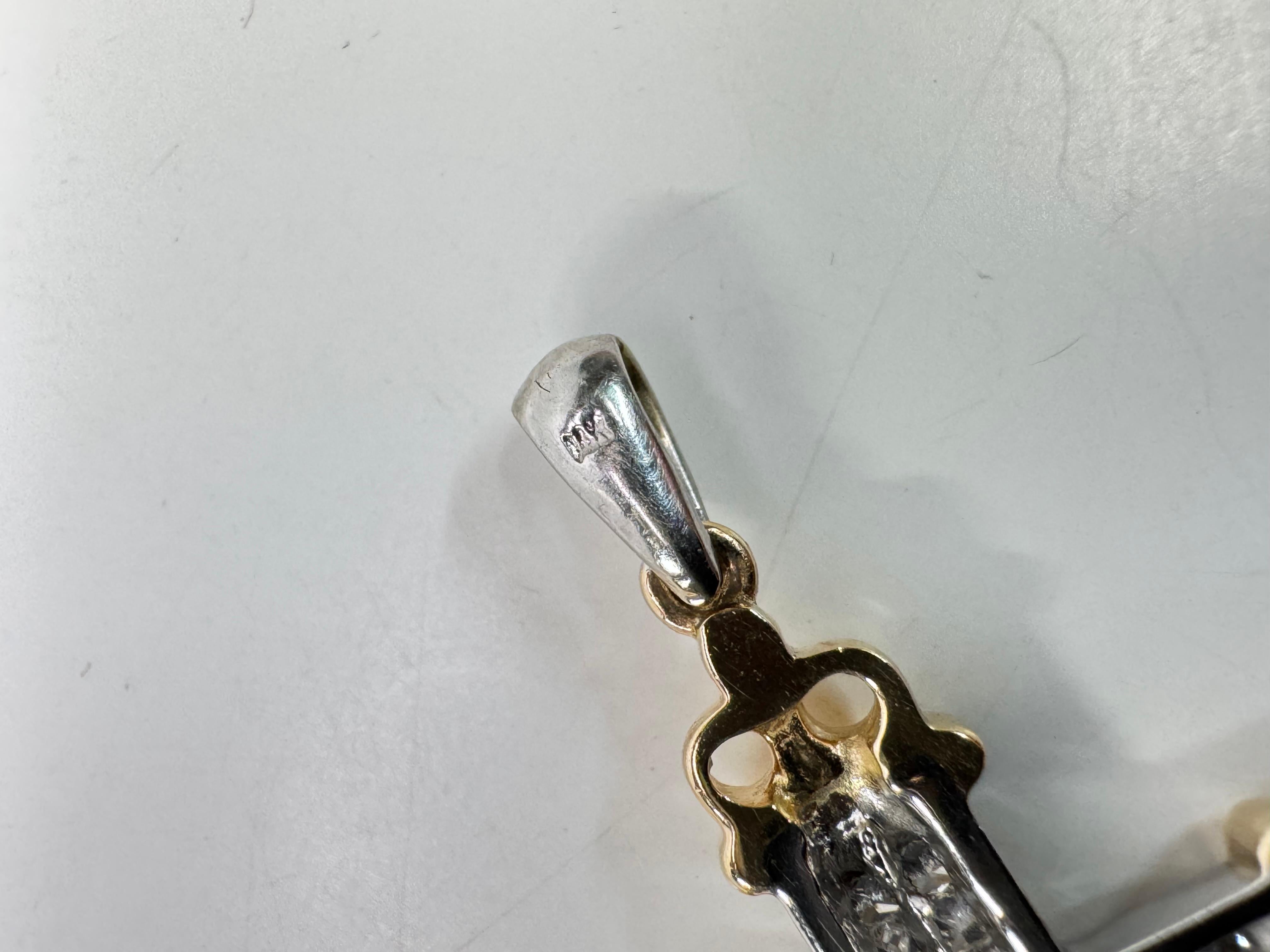 Dieser exquisite 14-karätige Kreuzanhänger aus zweifarbigem Gold ist ein atemberaubender Ausdruck von Glauben und Eleganz. Der fachmännisch gefertigte Ring besteht aus einer raffinierten Mischung aus Gelb- und Weißgold, die seine zeitlose