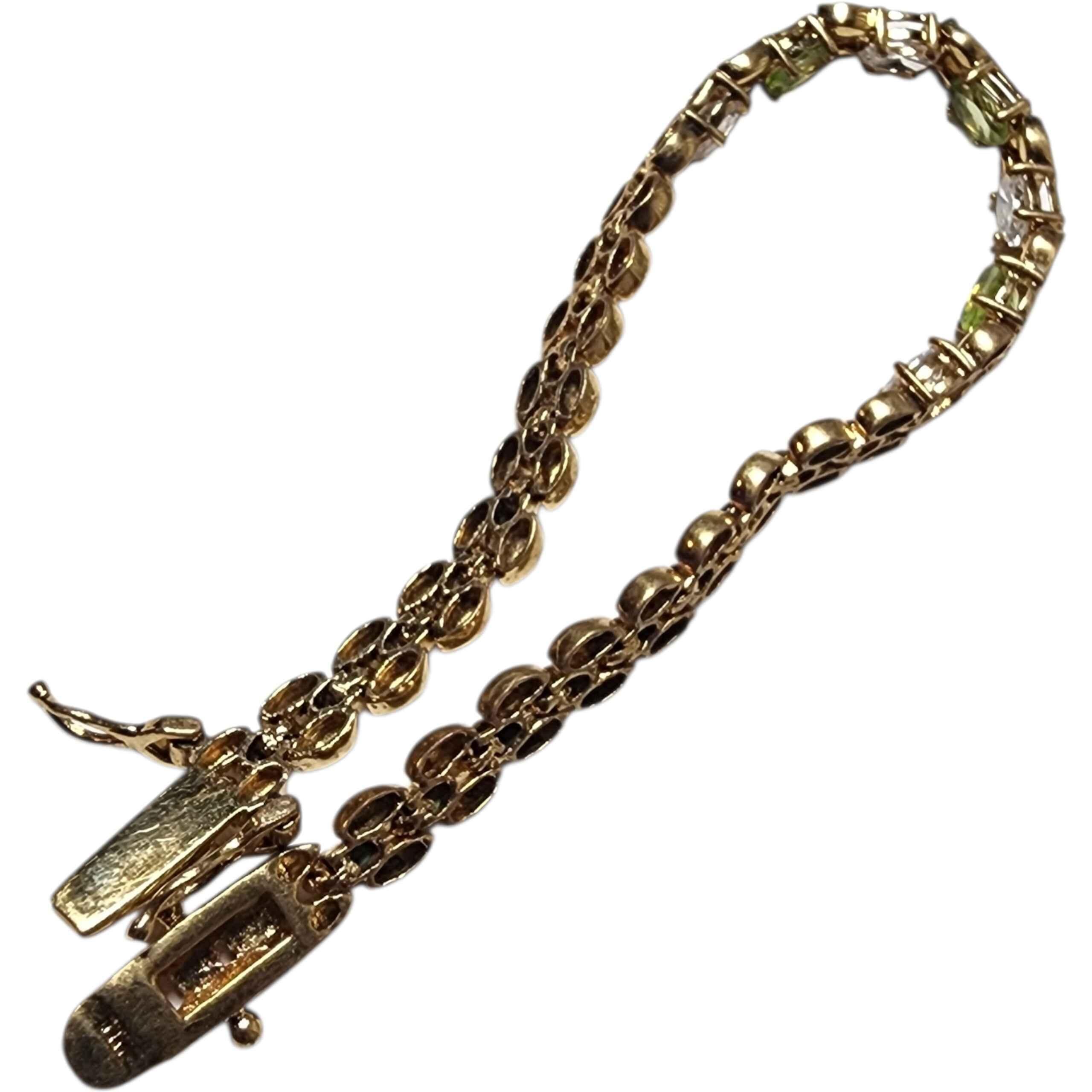 Vintage 14K Vermeil Vermeil Tennis Bracelet avec Peridot & White Topaz Oval Gemstones 
Un bracelet de tennis vintage raffiné en or 14 carats vermeil, serti de pierres ovales en péridot naturel et en topaze blanche. L'association d'un blanc éclatant