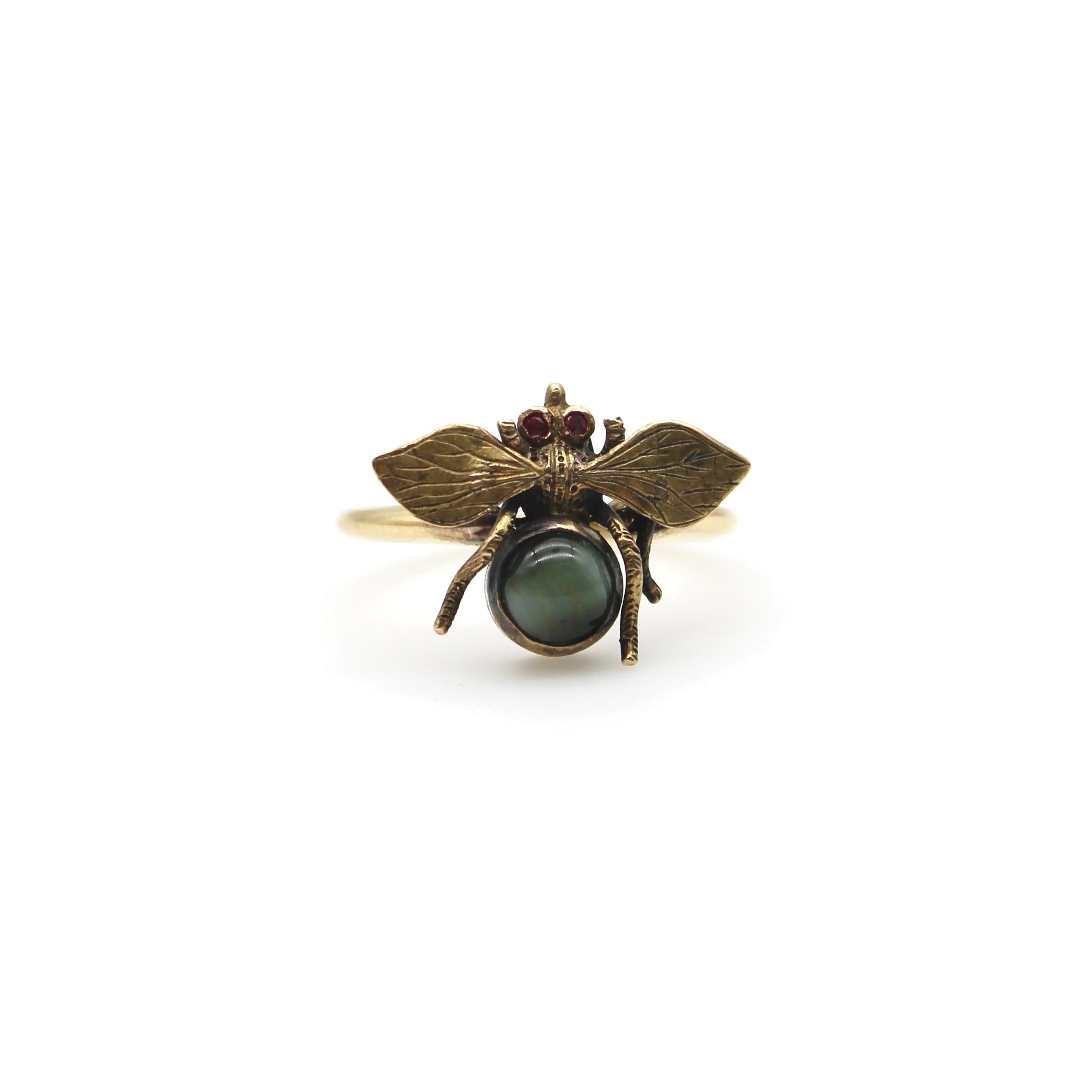 A beautiful Victorian era Bee ring made from a stick pin. It has bezel set rubies for eyes and a grey cats eye gemstone for the thorax. In the language of Victorian era symbolism and sentimentality, the bee came to signify keeping busy, teamwork and