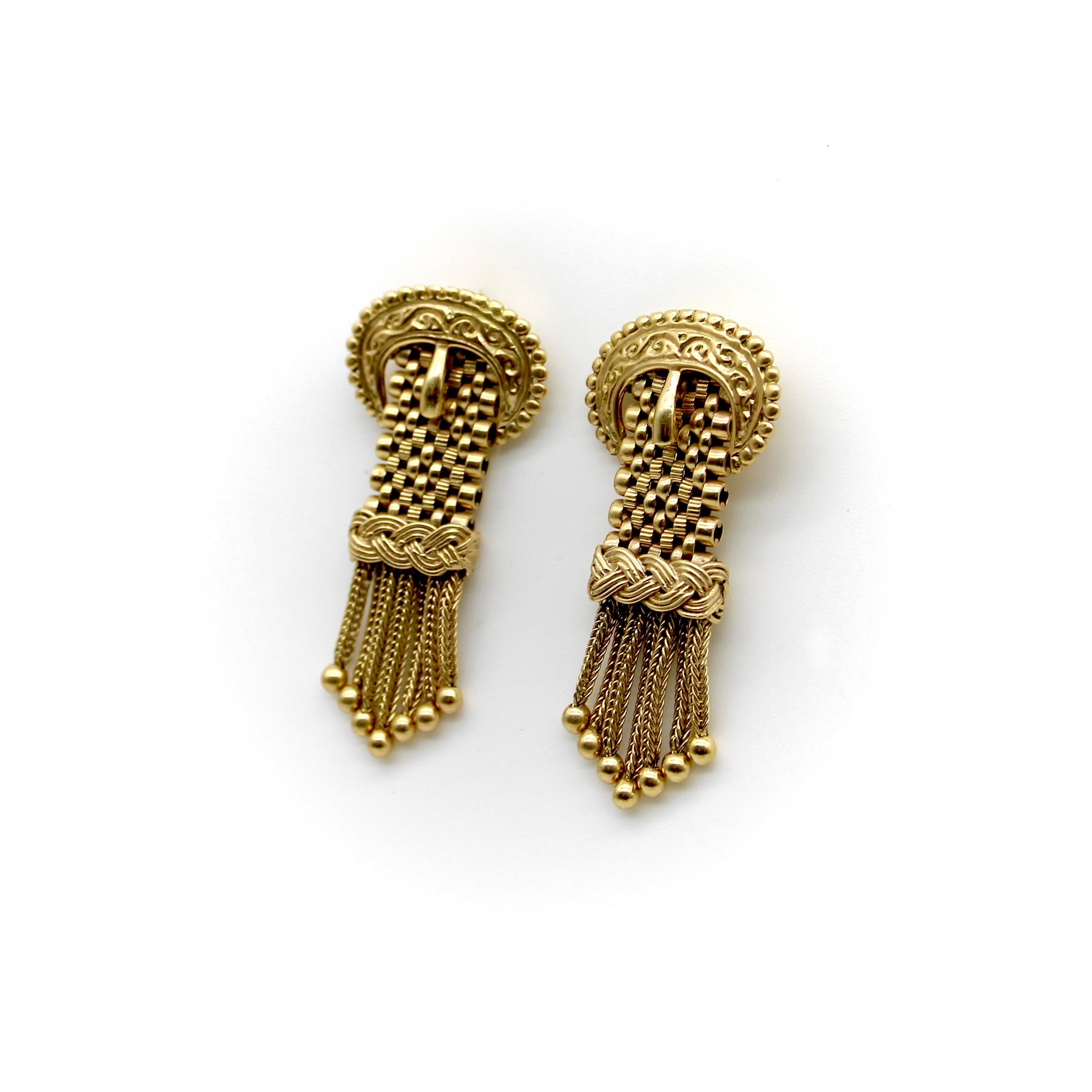 These stunning Victorian buckle earrings are crafted with bright yellow gold and feature delicate tassels that elegantly sway as they dangle. Each tassel is tapered to a pointed shape and arranged in ascending order towards the center, showcasing