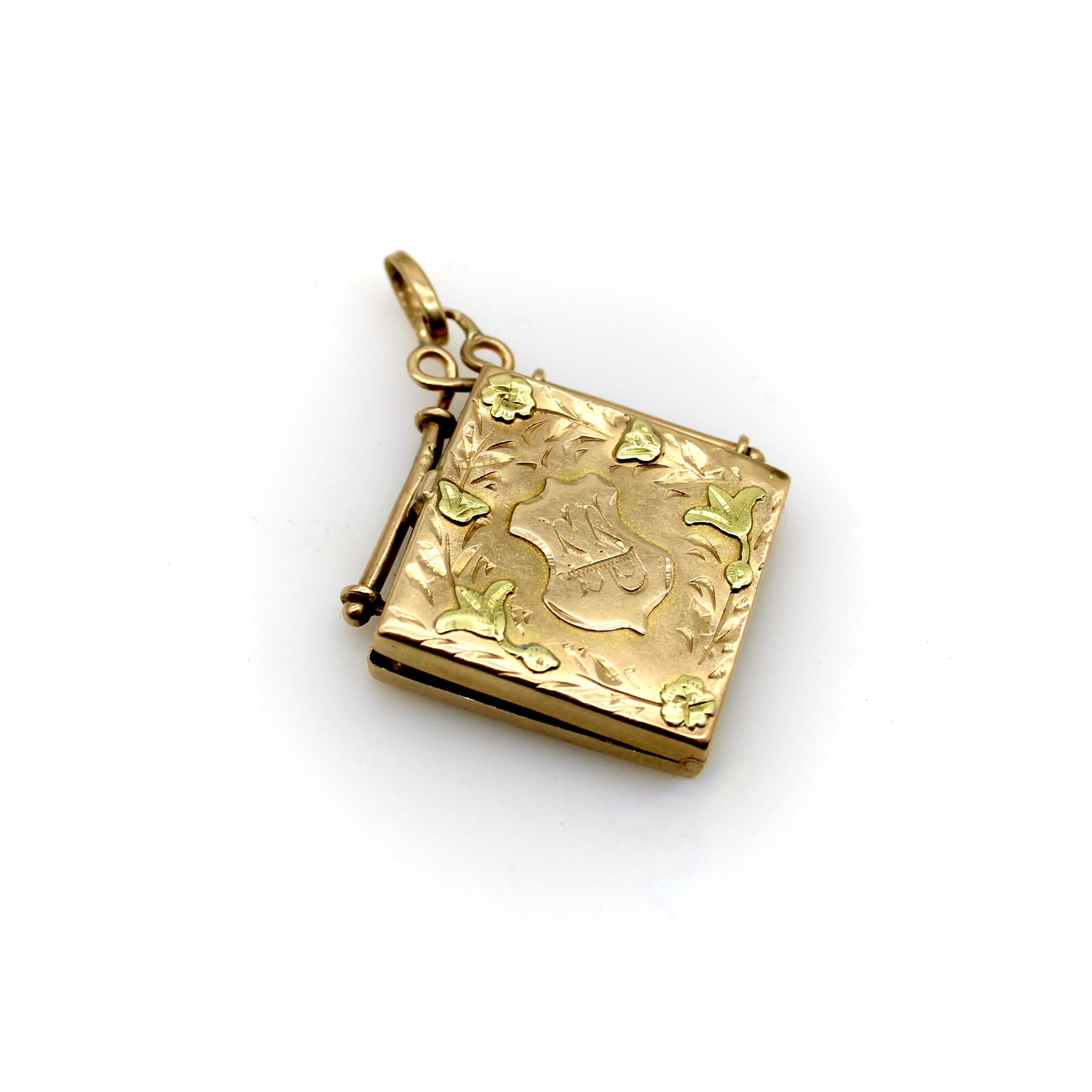 This 14k gold Victorian square fob locket is hand engraved with a shield surrounded by a vine of flowers and leaves. The shield has the initials S.S. with a P laid across it in a unique shape. The locket has two tones of gold—a rosy hue as the base