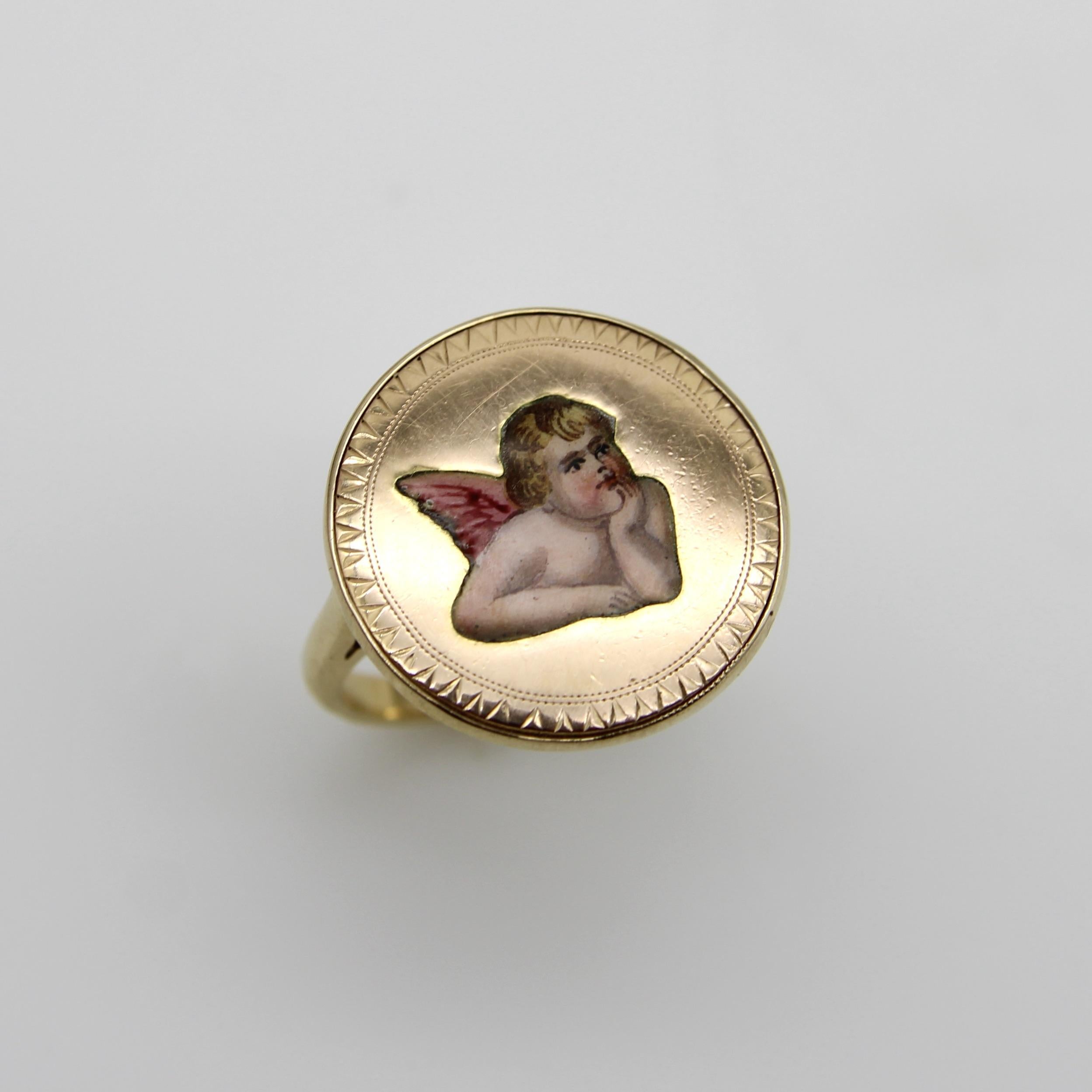 During the Victorian era, cherubs were a popular motif and this winged cherubs—perhaps cupid—sits with his head resting in his arms, a pose seen repeated in angel imagery from this time. The enamel portrait is flush with the medallion, beautifully