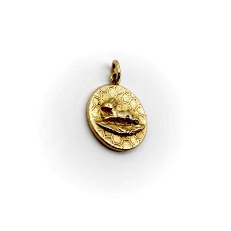 This is a precious 14k gold medallion charm from Kirsten’s Corner signature “Cute as a Button” collection. It is handcrafted from a Victorian era button and features a profile view of a jumping rabbit against a honeycomb background. The pedant has a