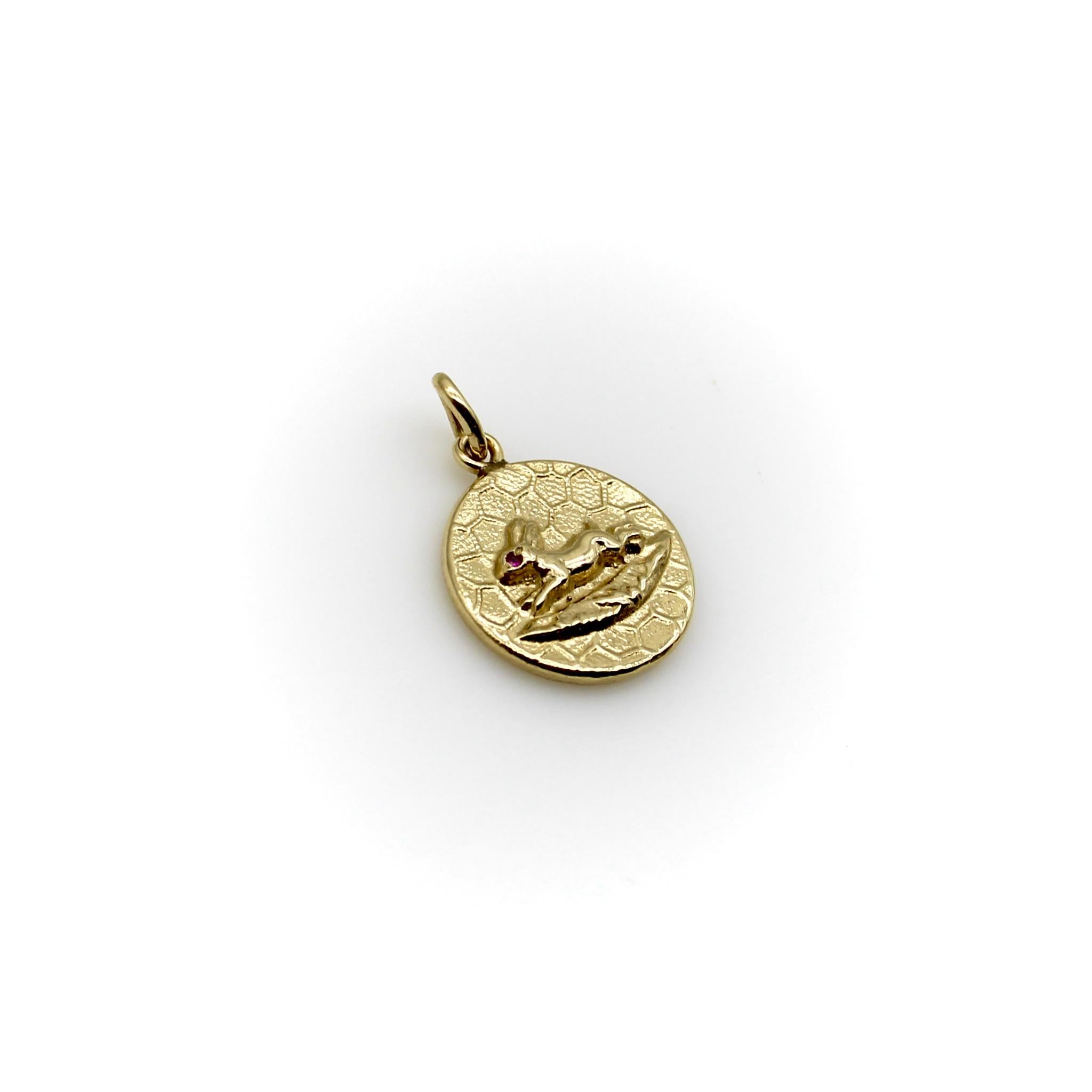 This is a precious 14k gold medallion charm from Kirsten’s Corner signature “Cute as a Button” collection. It is handcrafted from a Victorian era button and features a profile view of a jumping rabbit against a honeycomb background. The rabbit has a