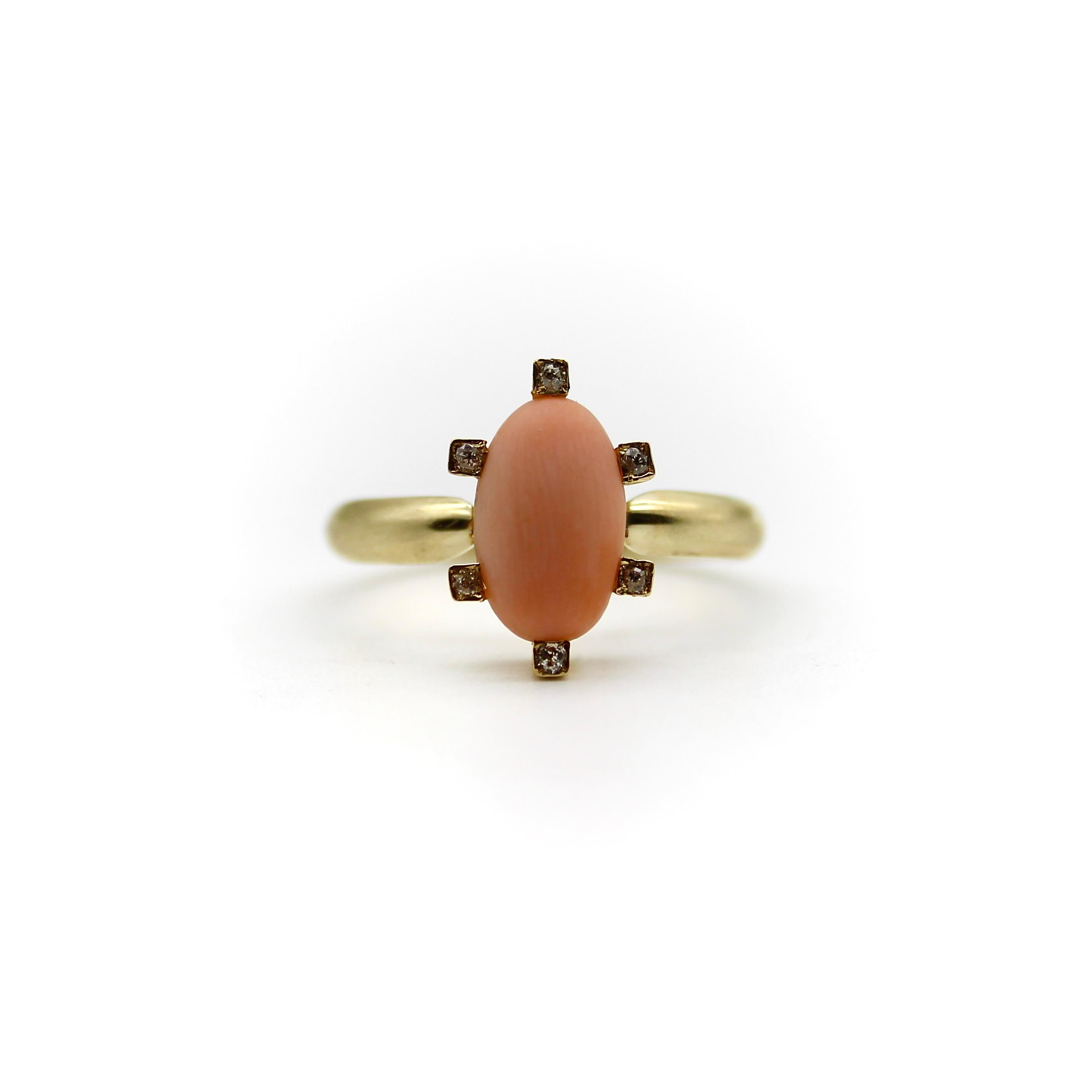 This pale pink coral cabochon is elegant and feminine, circa the Victorian era, and set on a 14k gold ring. The coral has a beautiful matte surface with delicate wood-like graining. The cabochon is surrounded by six Old Mine Cut diamonds, sweetly