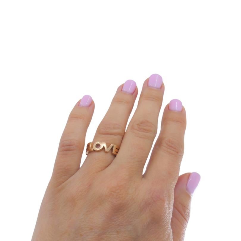A 14k gold ring with openwork design spelling out the word “LOVE” in connected capital letters. The cut out style gives an airy feel to the angular structure of the design. 
This Love ring makes a perfect Valentine’s Day gift, carrying a clear and