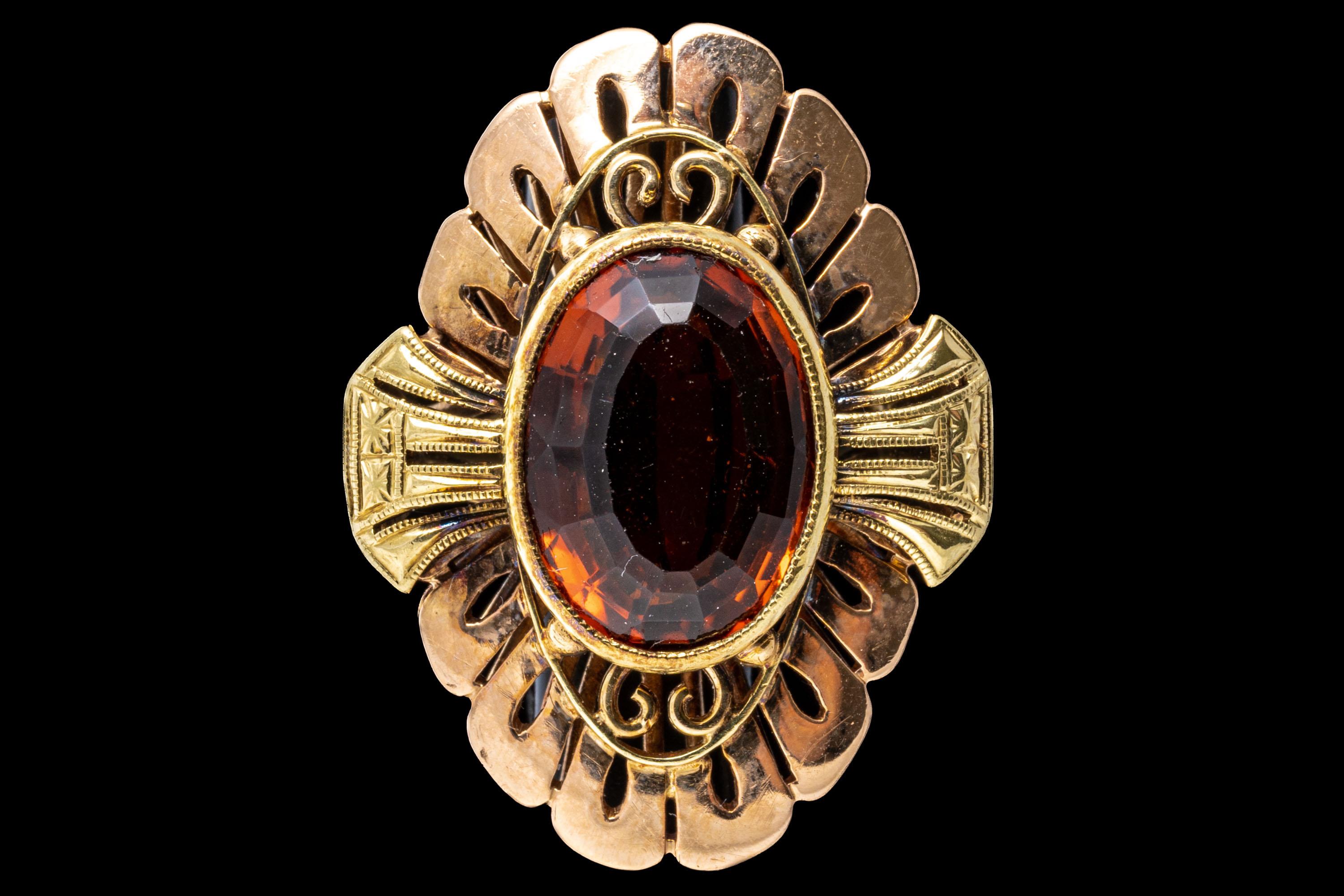 14k yellow and rose gold ring. This striking vintage ring features a center oval faceted, medium to dark orange color citrine, approximately 2.96 CTS, bezel set and surrounded by a rose gold, Art Deco style flower form, and accented by yellow gold