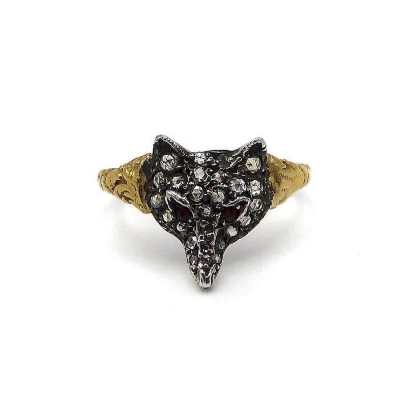 This striking ring features a sterling silver fox head with 27 pave rose-cut diamonds that are bead set (approximately .5mm to 1mm each) and 2 ruby eyes (approximately 1.5 mm each). The band is 14k gold and has scrolling floral detailing down both