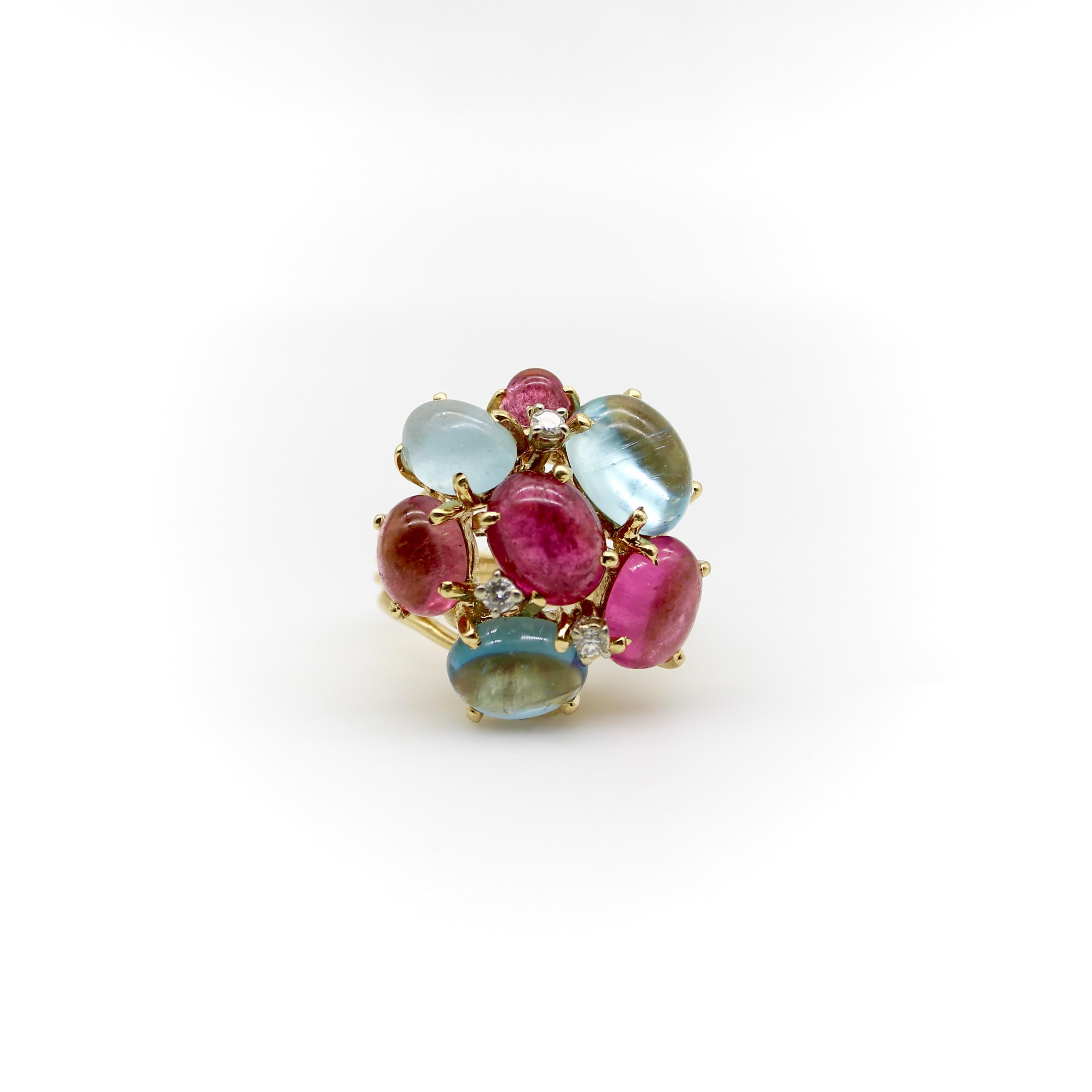 This 14k gold vintage cocktail ring is a combination of beautiful aquamarine and pink tourmaline cabochons in various sizes of ovals. The stones are prong set and offer a fun, delicious candy-like ring. Three round cut diamonds are interspersed