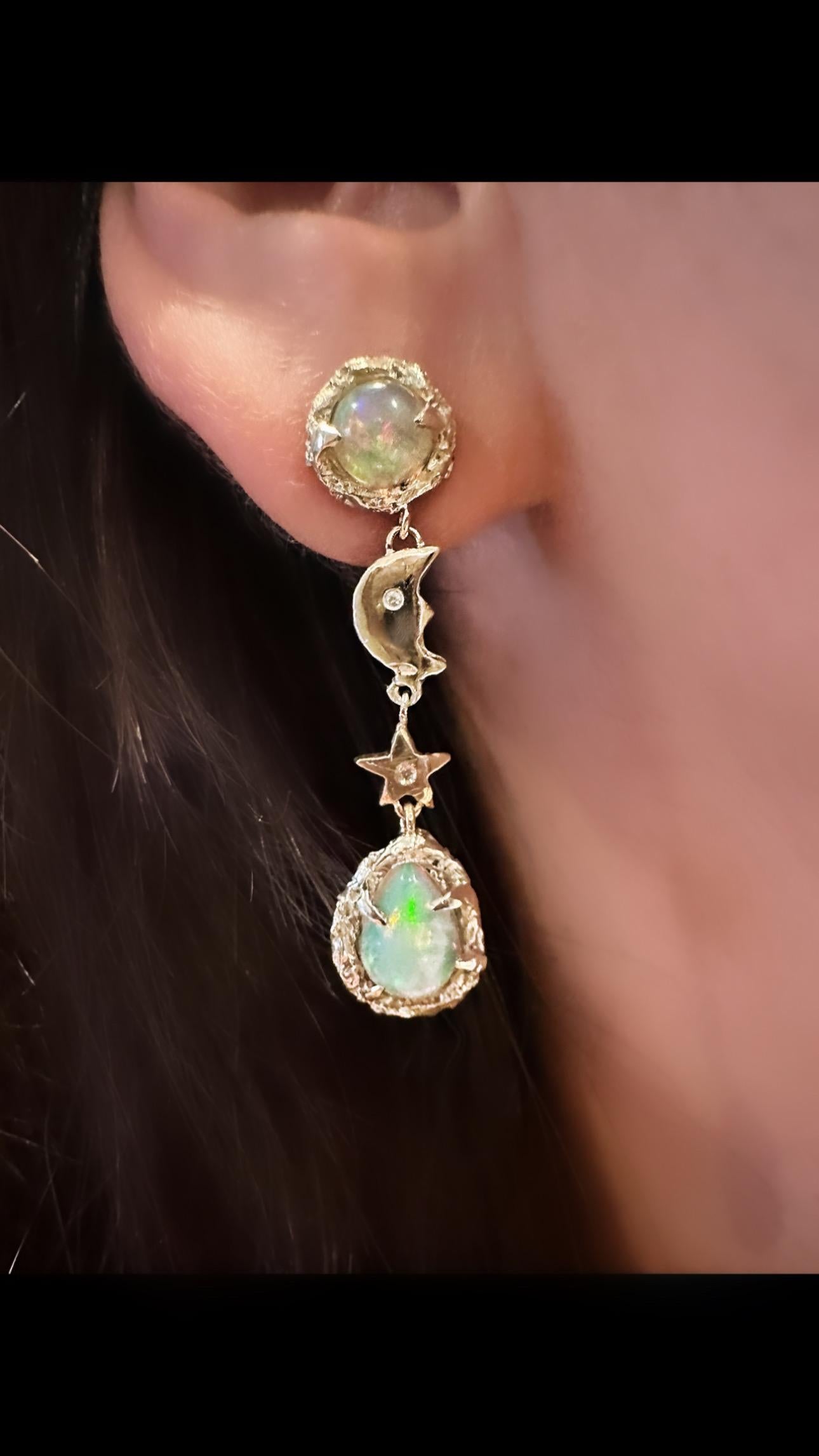 Bring the beauty of the galaxy to your ears with these one-of-a-kind 14k yellow gold iris moon and stars opal with diamond earrings! 🌙✨ The opals in these earrings have a stunning galaxy-like fire that will leave you mesmerized. Plus, the diamond