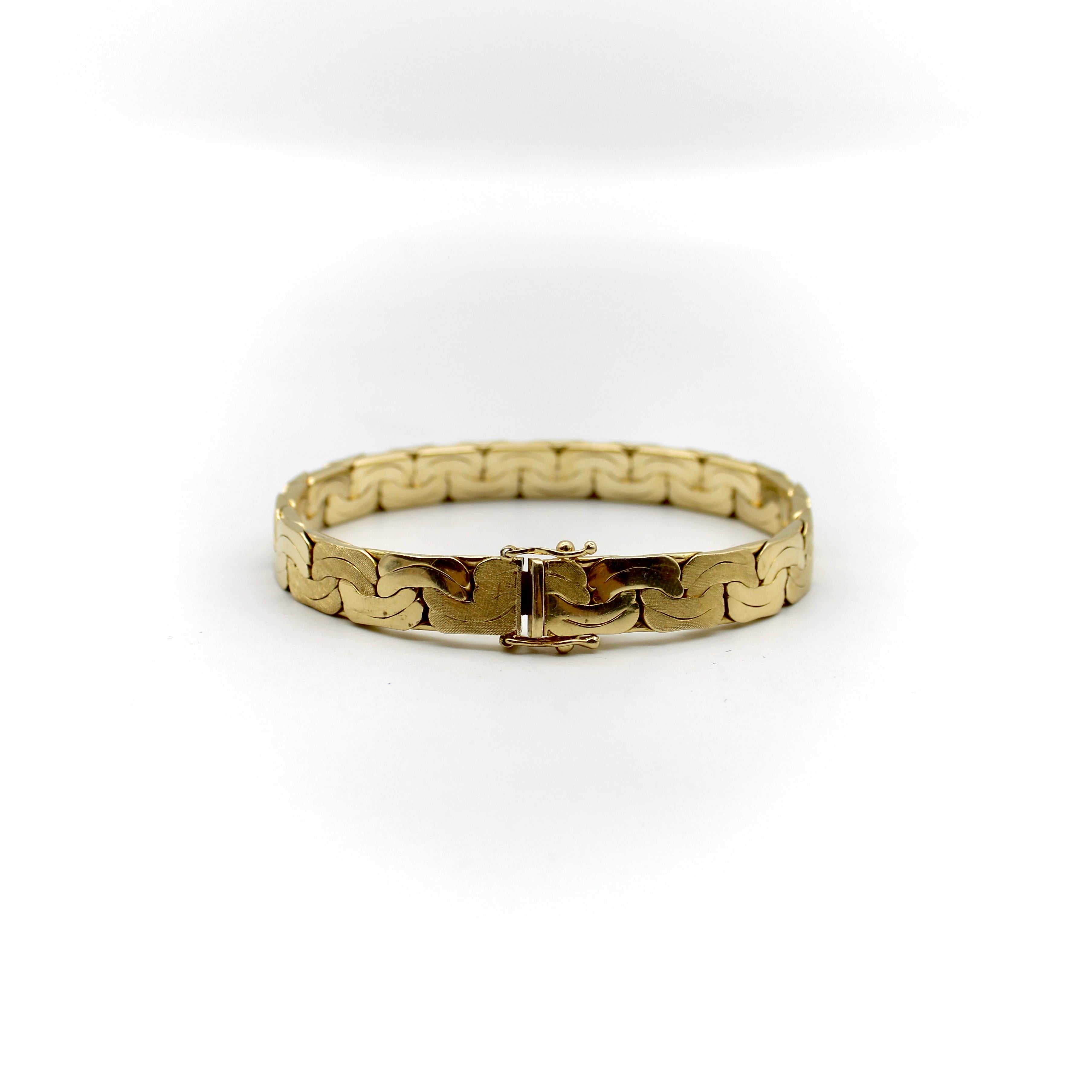 Circa the 1980’s, this 14k gold vintage bracelet has a geometric design and solid, fluid form. The link appears squashed, with a curved line down its center, and an alternating Florentine finish. It is a double link, flattened on both sides, so that