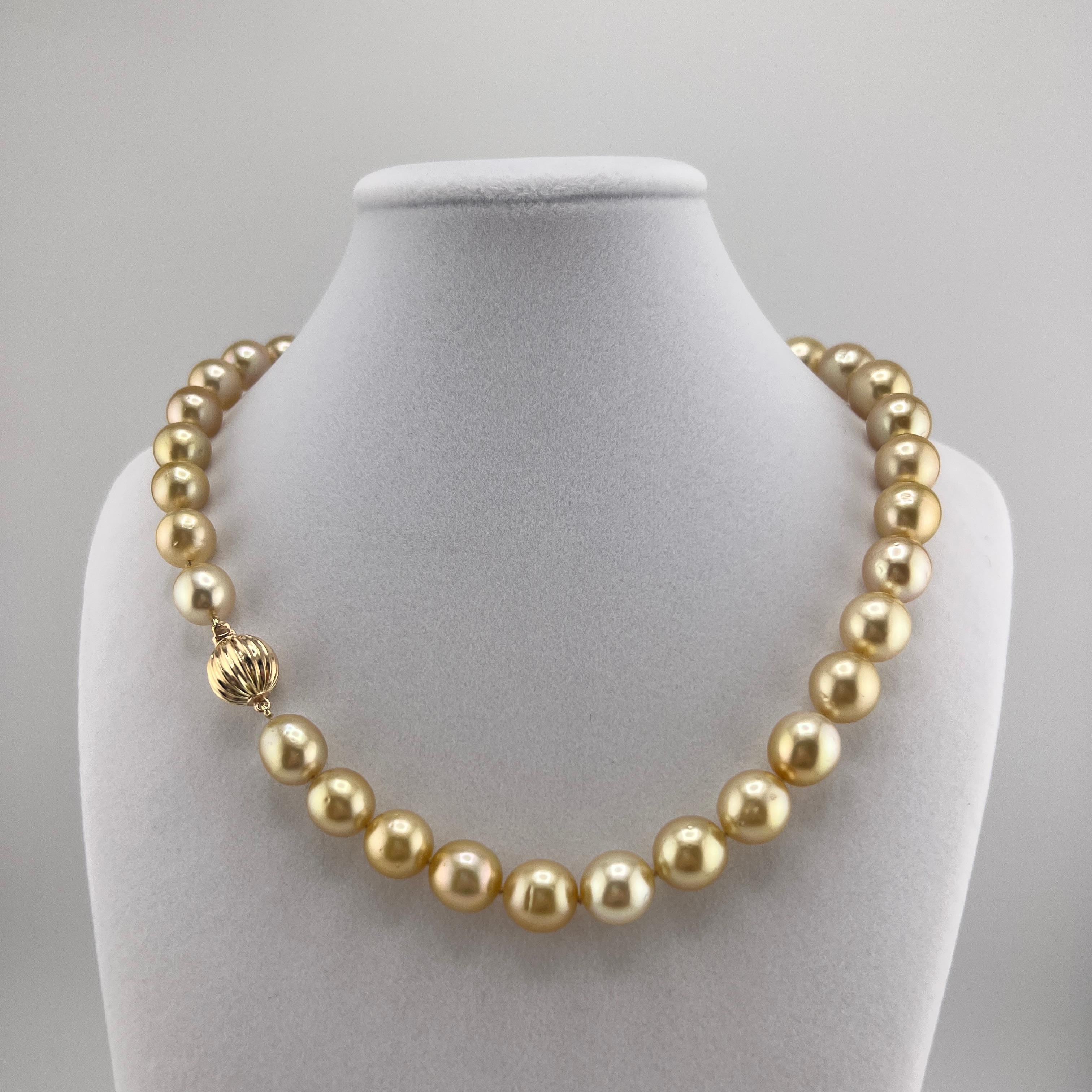 A wonderfully lustrous 17 inch strand of naturally golden 10-13mm South Seas Pearls on a 14k yellow gold clasp. The pearls are round with minor blemishes. Included is an AIGL report appraising the pearls at $8,760. 
