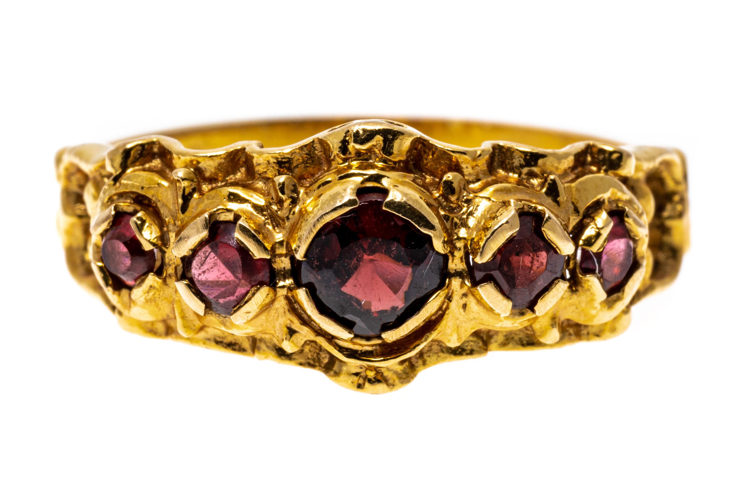 14k yellow gold ring. This ornate ring is a band style set with graduated, round-faceted, medium to dark color garnets, approximately 0.38 TCW, decorated with an ornamented pierced frame.
Marks: 14k
Dimensions: 9/16