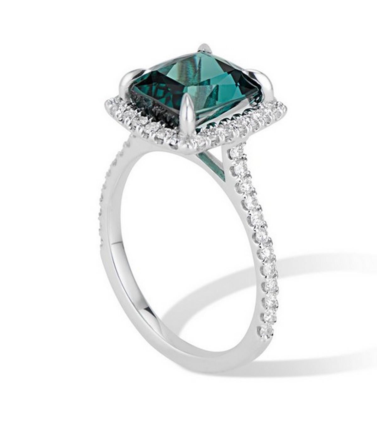 Stunning 4.68ct Cushion Cut Green Tourmaline accentuated by a scintillating halo of brilliant diamonds set in a high polish white gold diamond band.
The color is a unique deep blue green making it a special one of a kind piece.

All our gemstones