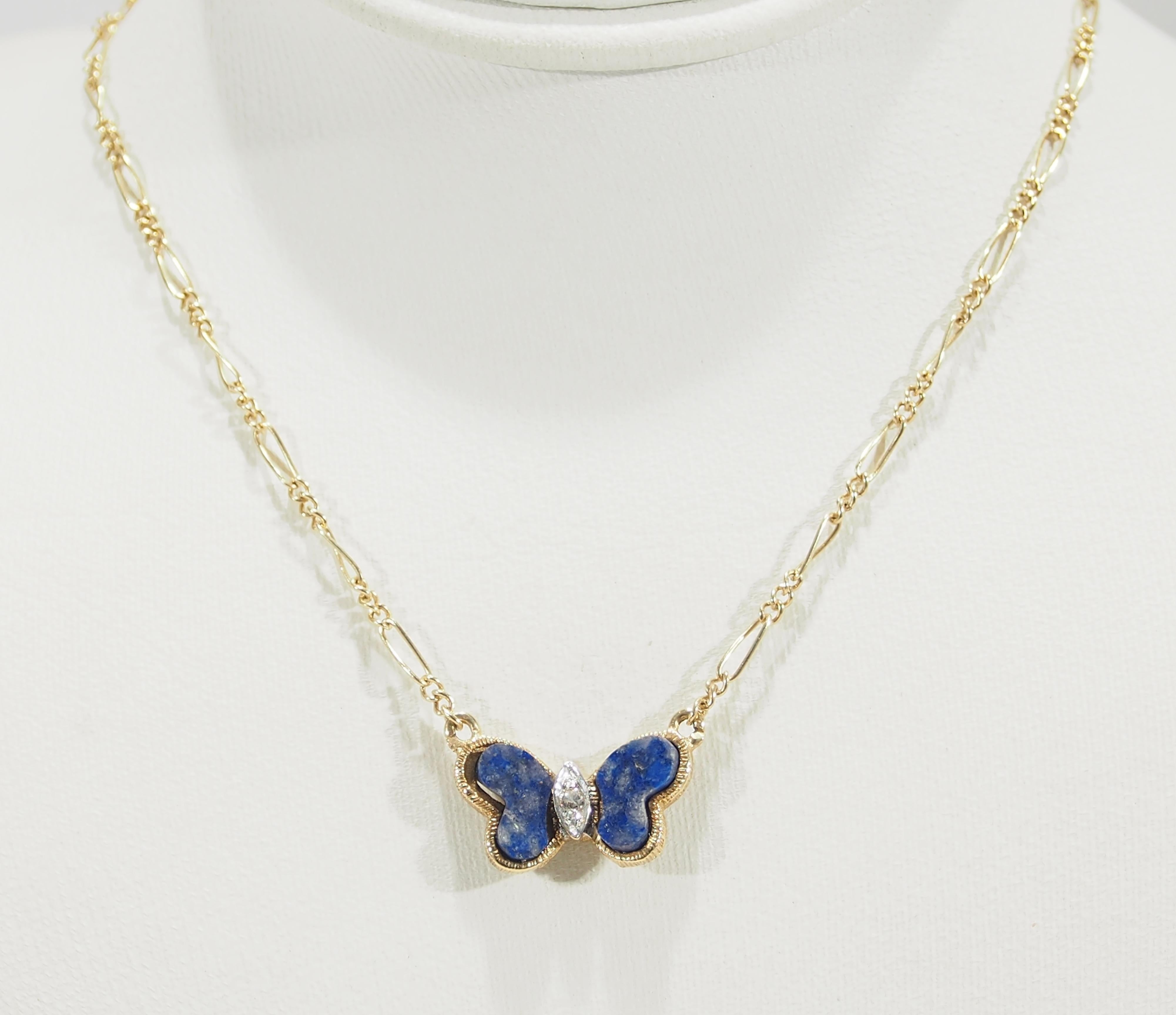 14K Yellow Gold Vintage Butterfly pendant from Hammerman Brothers sparkles with (3) Round Brilliant Cut Diamonds, G-I in Color, VS in Clarity, approximately 0.02 total weight and Lapis Lazuli wings. The pendant is attached to a lightweight Figaro