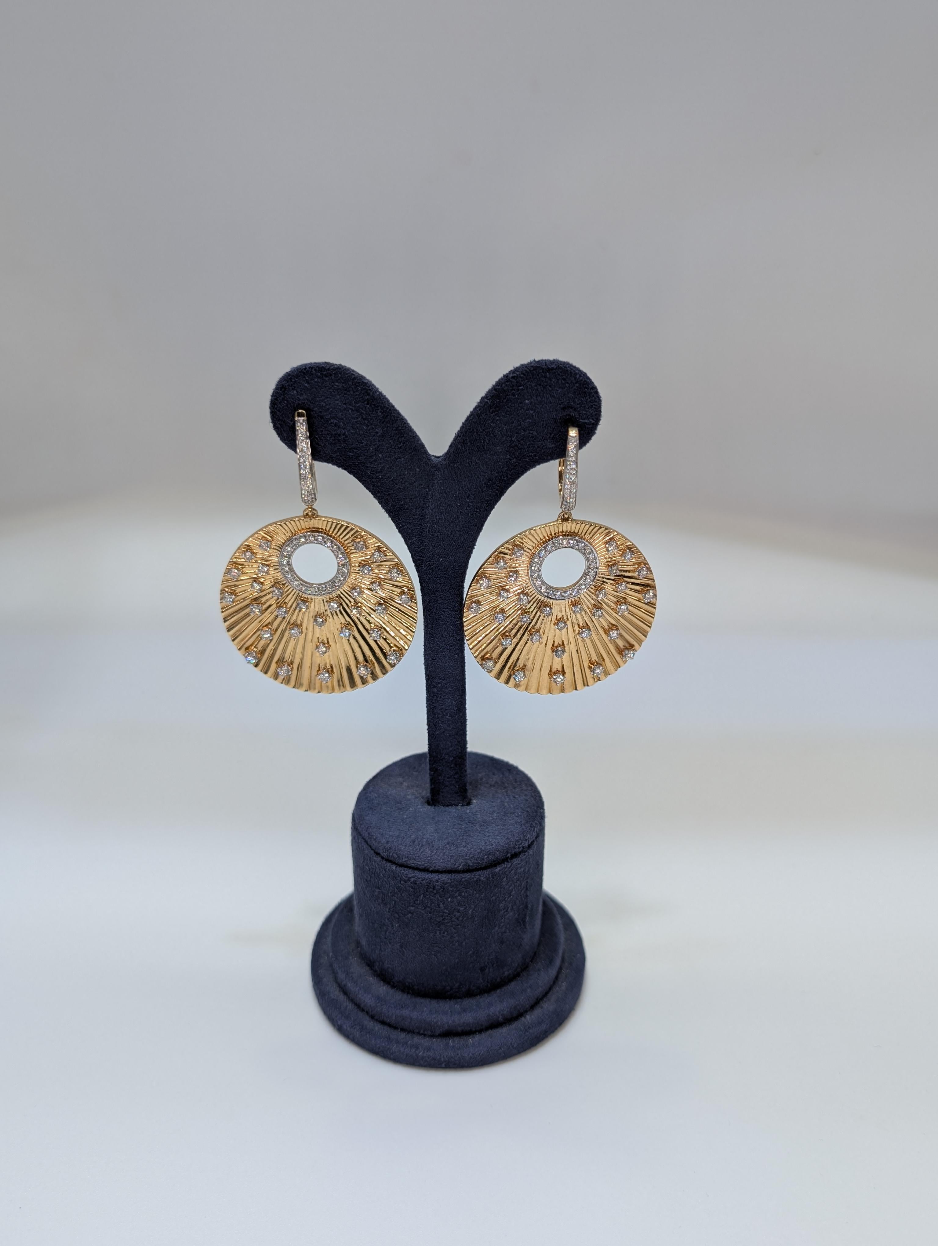 Questi raffinati orecchini pendenti in oro a 14 carati sono caratterizzati da un bellissimo design a cerchio sfaccettato che aggiunge un tocco di eleganza a qualsiasi look. Gli orecchini sono impreziositi da 3,43 carati di splendidi diamanti,