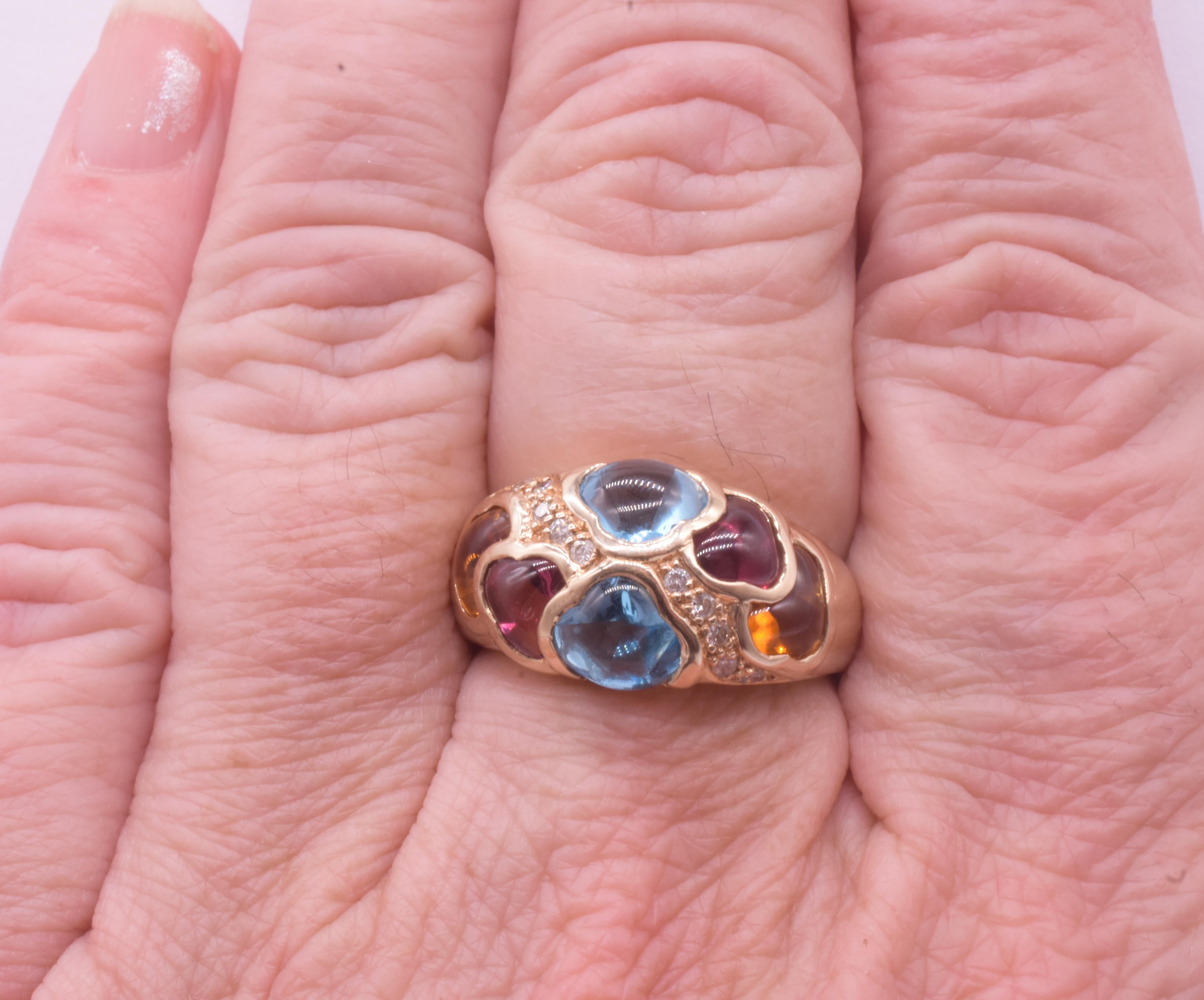 We love this 1960's sinuous cocktail ring. With its  2 hessonite, 2 red garnets 2 blue topaz stones and 10 diamond accents (a ribbon of 5 diamonds on each side) this ring mesmerizes with its contrasting colors and textures.
 
The ring has curvaceous