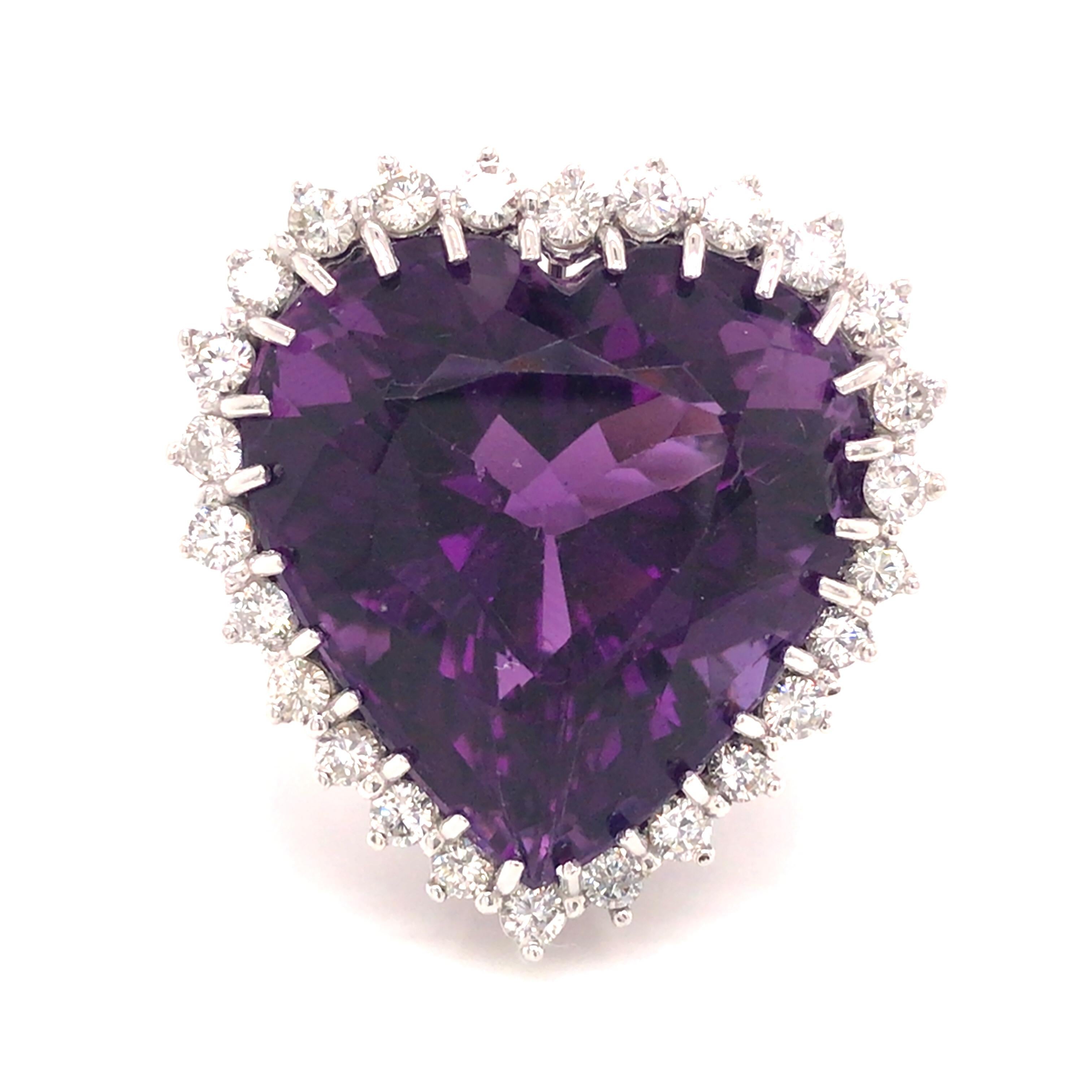 Heart Shape Royal Violet Amethyst Diamond Halo Ring in 14K White Gold.  Round Brilliant Cut Diamonds weighing 1.64 carat total weight, G-H in color and VS-SI in clarity are expertly set in a Halo surrounding the 33 Carat Royal Violet Heart Amethyst.