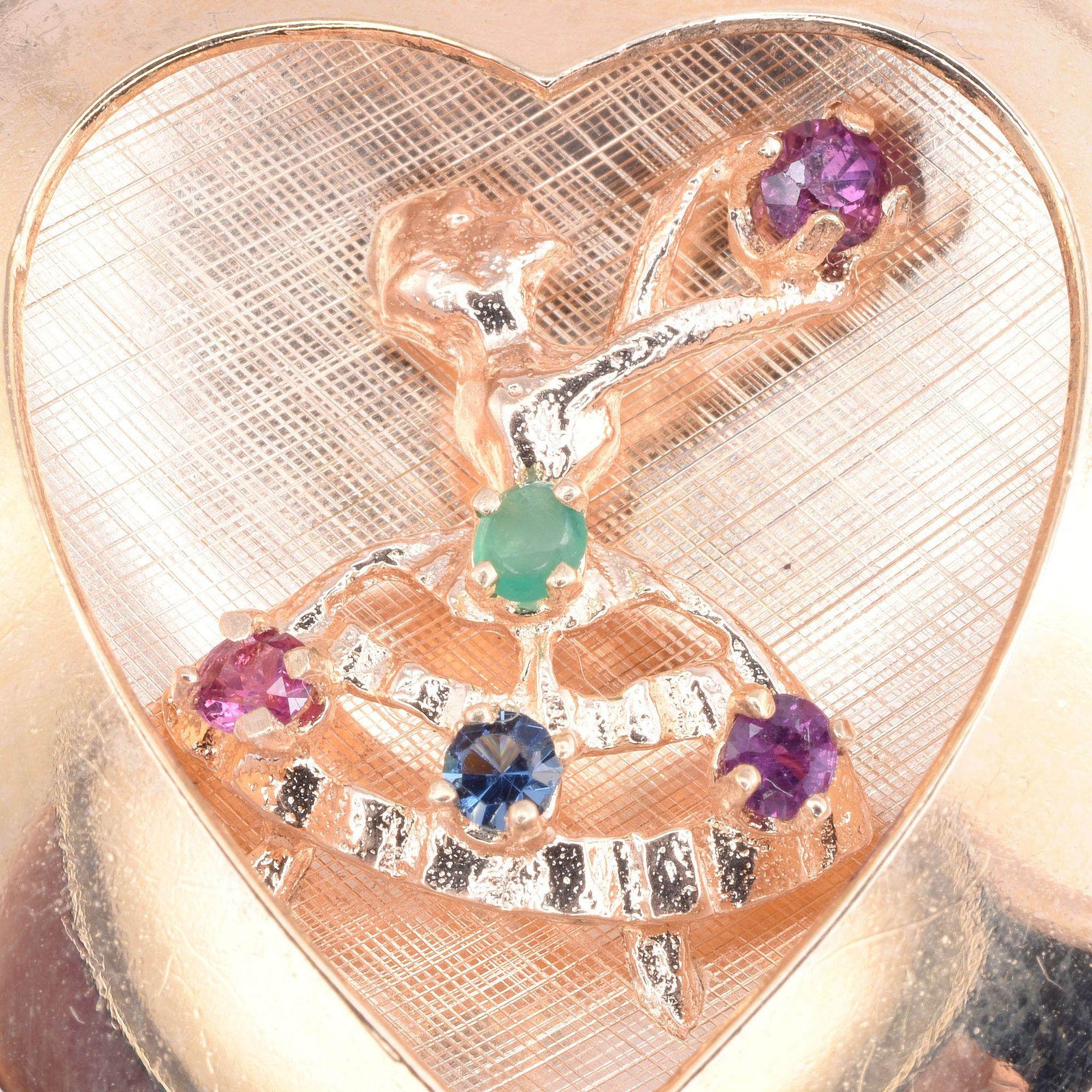 Vintage 14K heart with dancer charm or pendant, circa 1950. This vintage heart charm or pendant is crafted in 14 karat gold and features a dancing lady accented with colored stones. [KIMH 542]