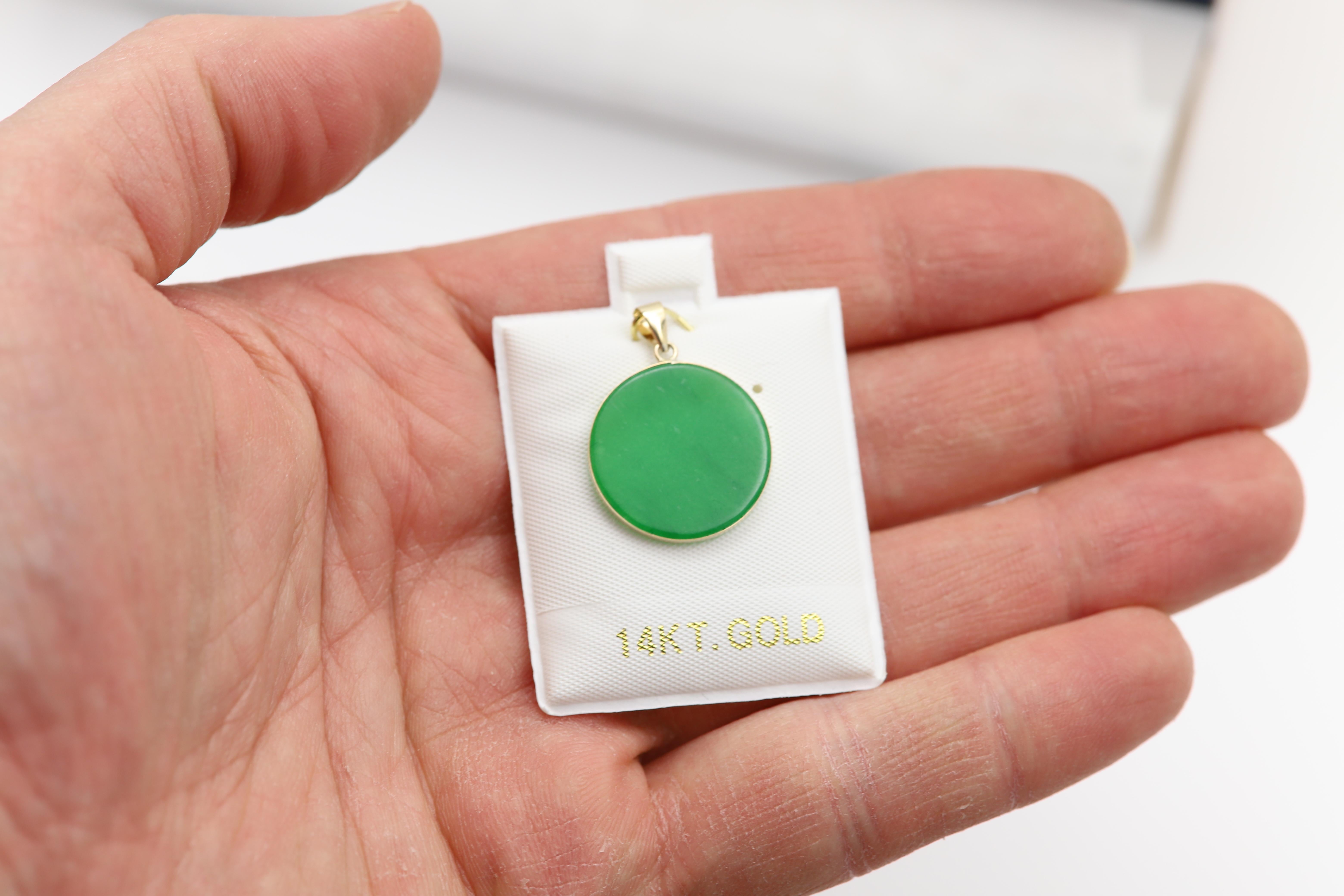 Beautiful Jade Round Circle Disc Pendant
14k Yellow Gold 
Natural jade with color treated (standard and common).
overall weight 2.2 grams (without a chain).
Size: approx  20 mm in Diameter.
Thickness: 2.0 mm
Chain is 14k yellow gold, basic cable