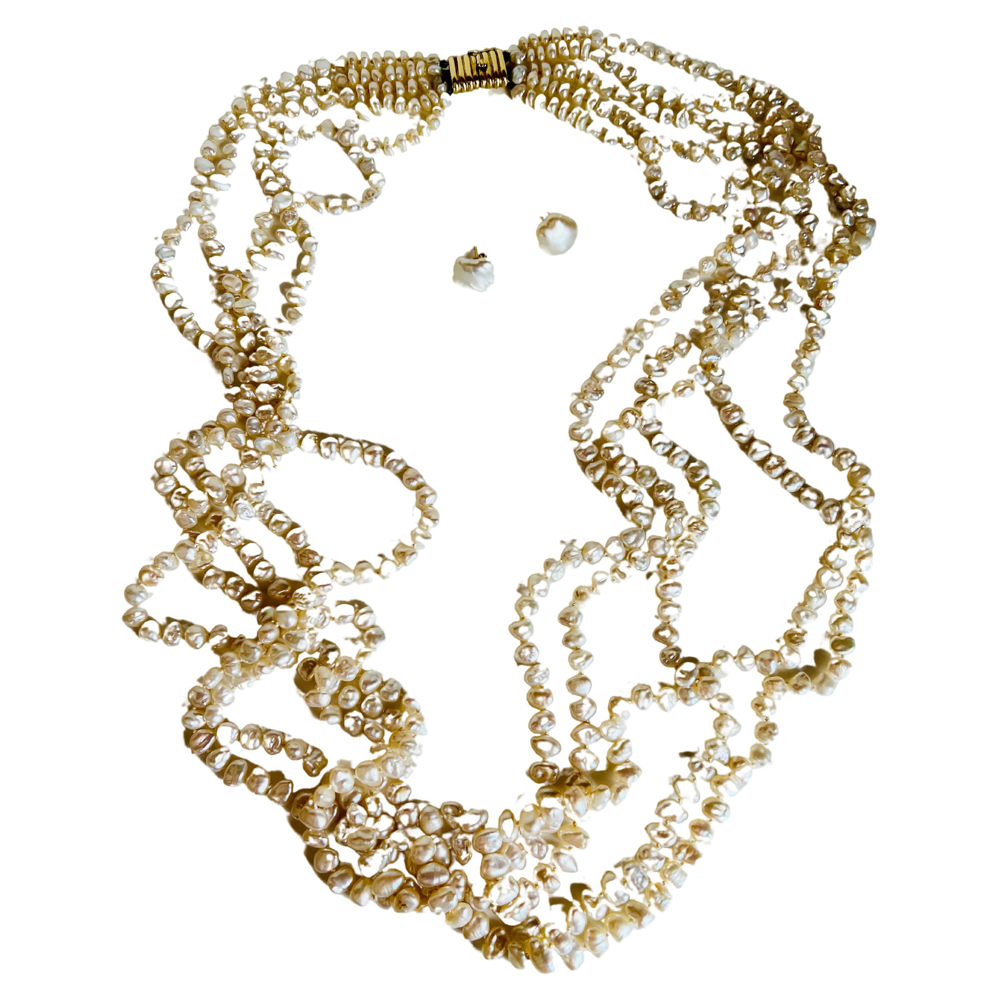 Elevate your collection with this 14k yellow gold cultured pearl necklace and earring set. The torsade necklace is composed of five strands of numerous Keishi freshwater cultured pearls adding a touch of haute couture and runway glamour, making it