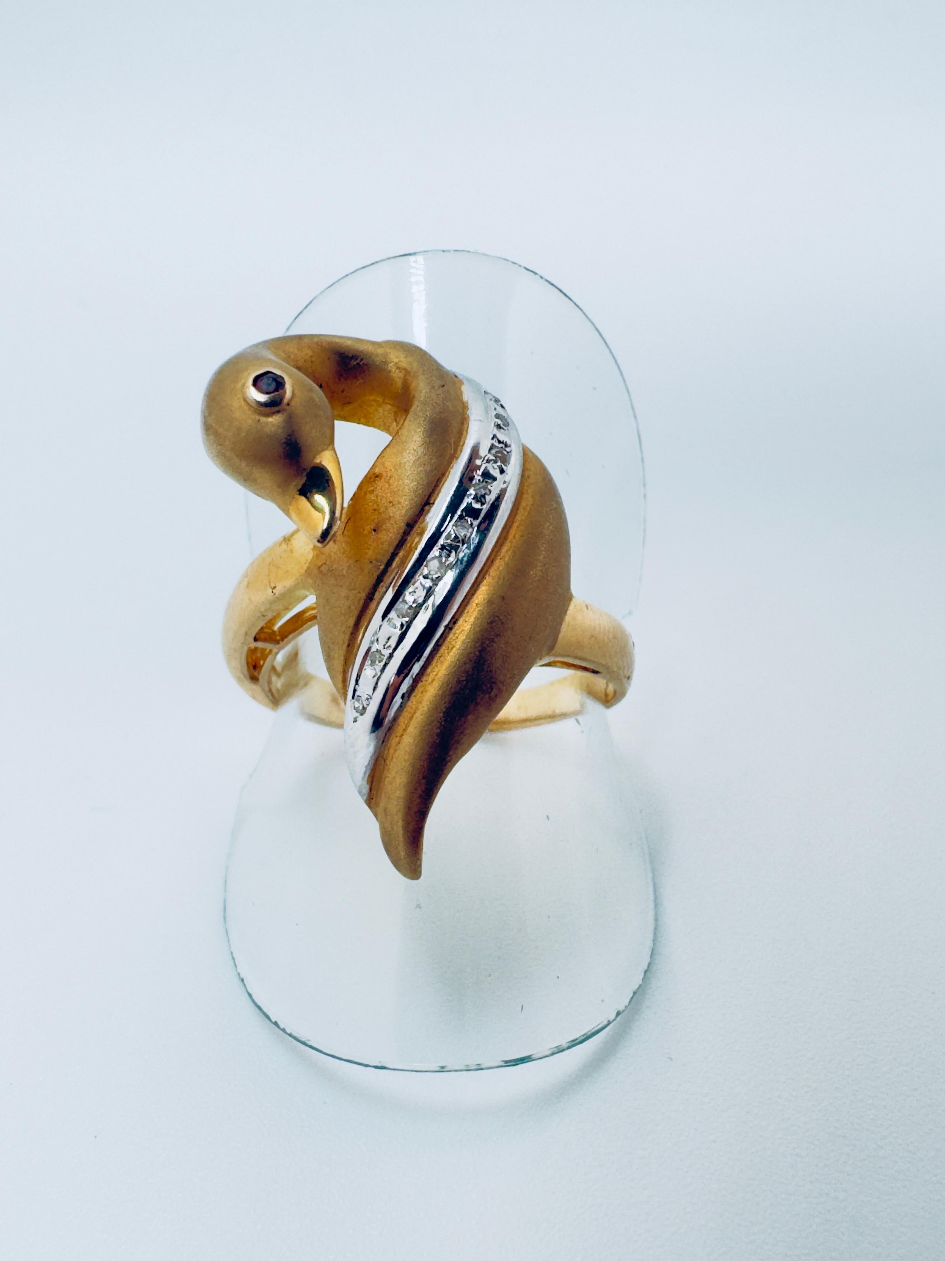 This elegant ladies’ ring is crafted in 14 karat yellow gold and features a graceful swan motif, symbolizing beauty and elegance. The design is adorned with nine round brilliant-cut diamonds, all bezel set for a secure and refined look, adding a
