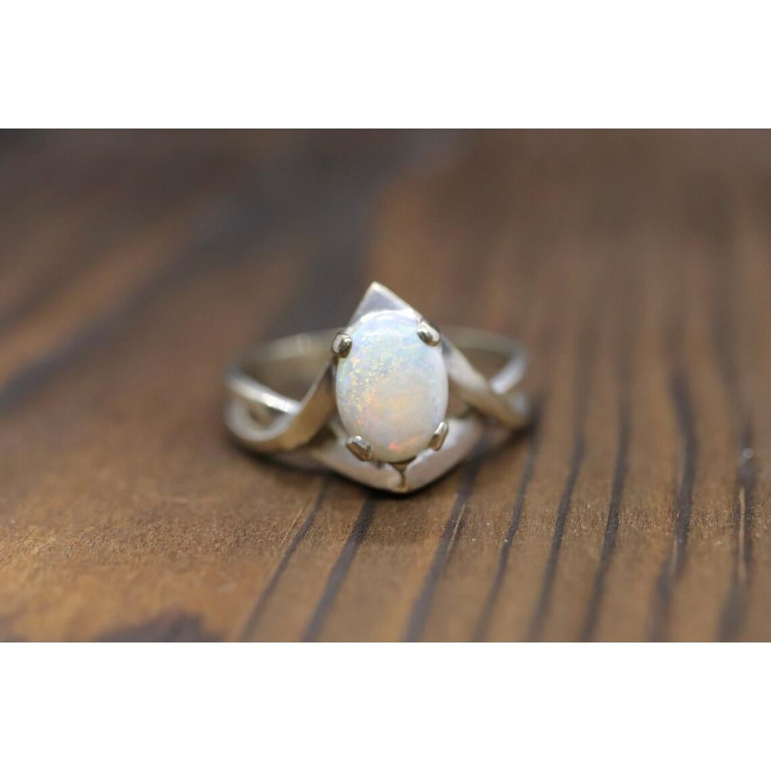 Vintage from the 1980s
Size: 6 1/2 US
Materials: Gold
Gemstone: Opal
Gem color: White

Band color: White

A very clean, simple and dainty ring. Oval opal crystal prong set into a Claw claw.

Condition: Shows no to limited signs of wear.

Details
6mm