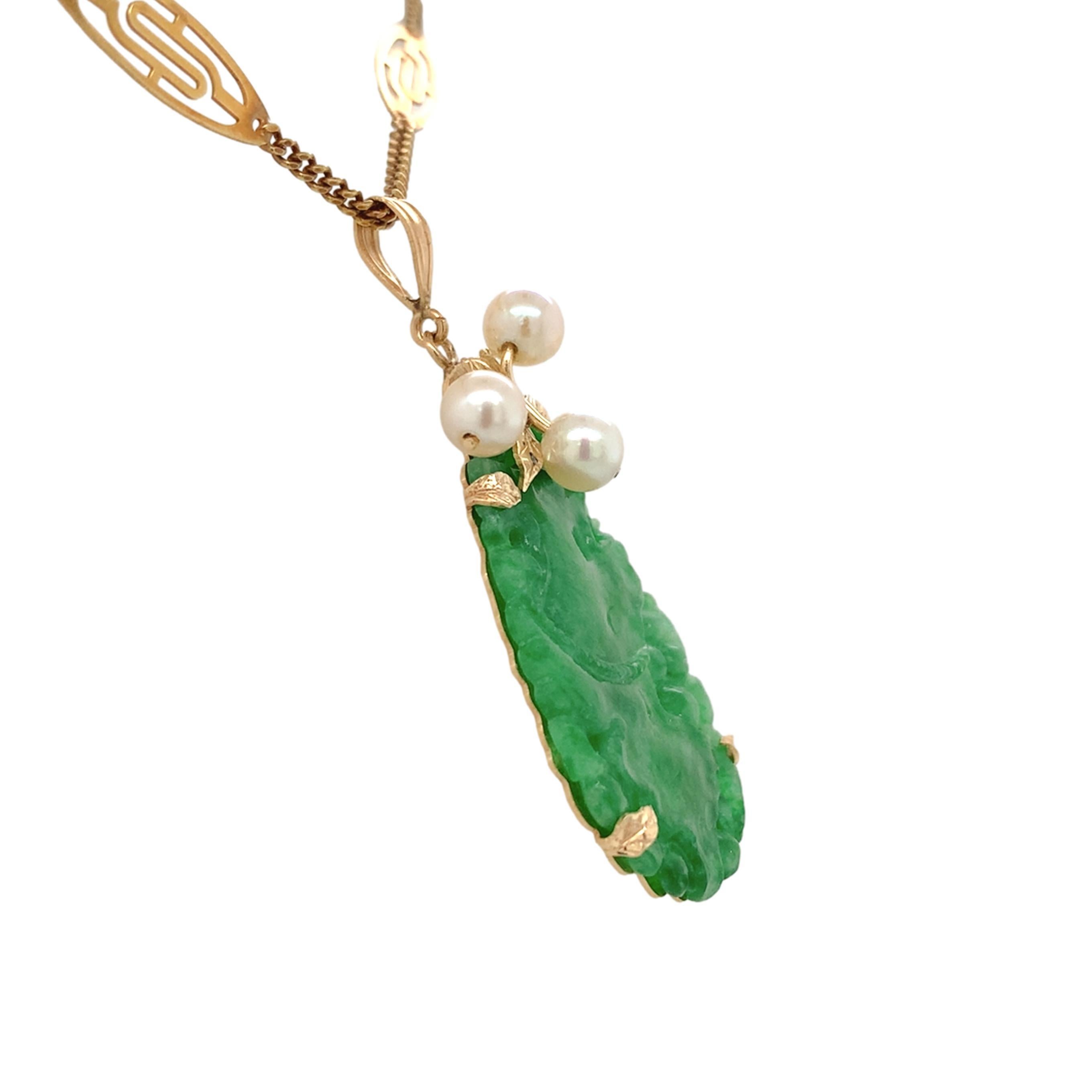 Un pendente in oro giallo 14K con giada verde intagliata e perle coltivate. Il ciondolo ha un rapporto GIA #2235536727 che attesta la giada naturale A, senza alcuna indicazione di colorante. La giada misura 31,11 mm x 19,56 mm x 1,81 mm ed è di