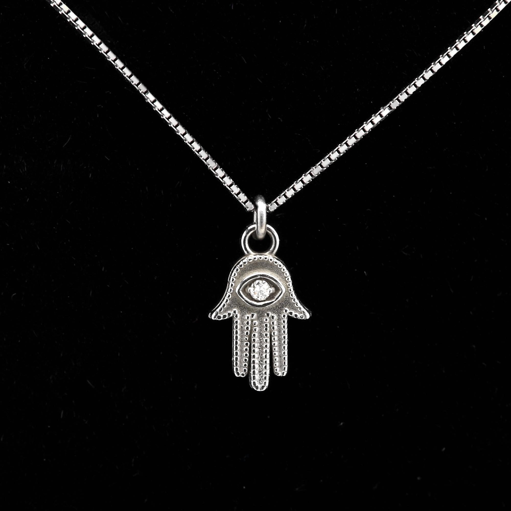 Mini Hamsa del malocchio 
Oro bianco 14k circa 1,40 grammi
Catena - catena a cassetta da 16' pollici (chiusura a molla)
Piccolo diamante centrale di circa 0,01ct GH-SI 
Dimensioni complessive della mano 8 mm di altezza e 5 mm di larghezza (8x5