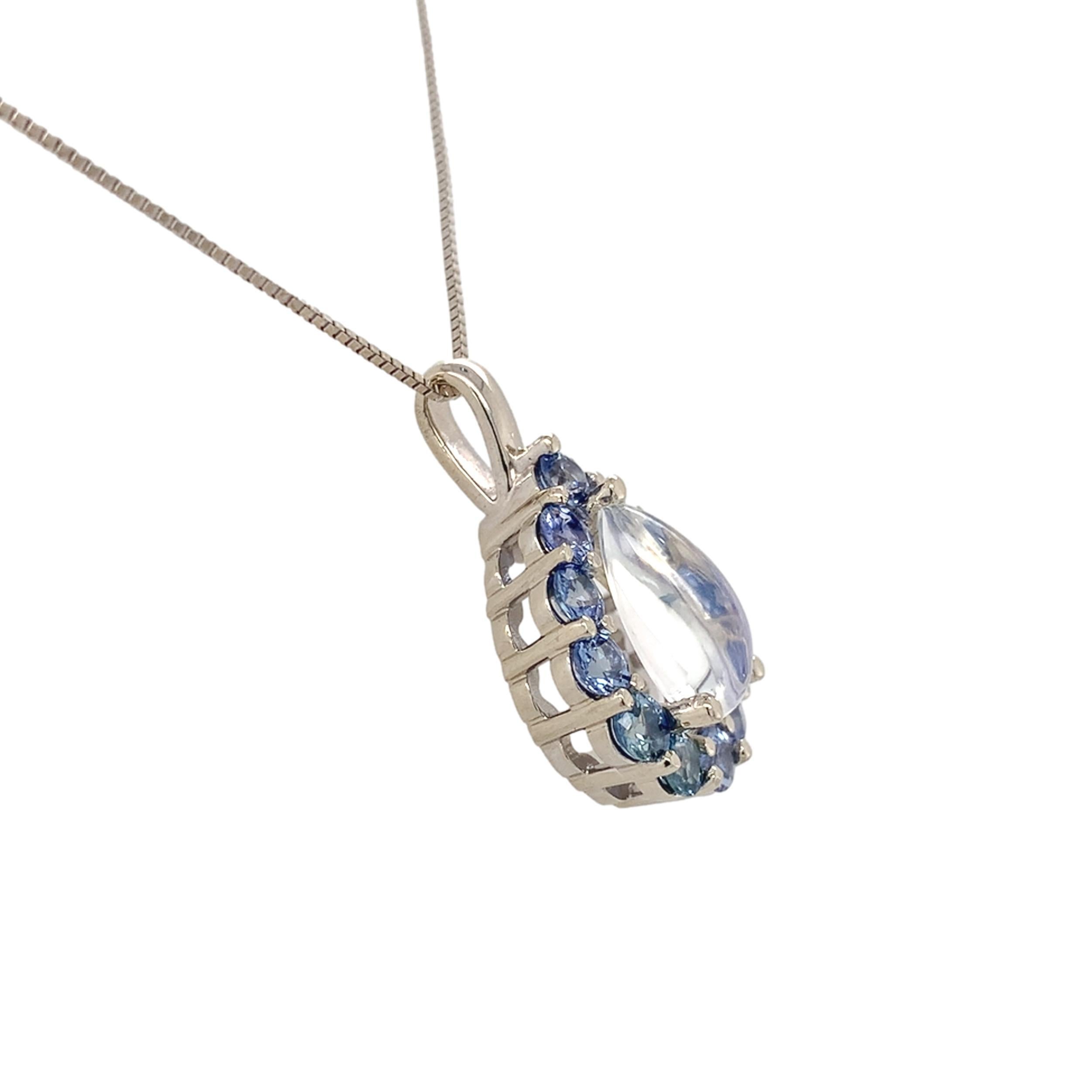 Pendente in oro bianco 14K con pietra di luna e zaffiro blu. L'autentica pietra di luna di Ceylon estratta a forma di pera e tagliata a cabochon è trasparente con riflessi blu. Misura circa 12 mm x 7 mm e pesa 2,34 carati. Ci sono 12 zaffiri rotondi