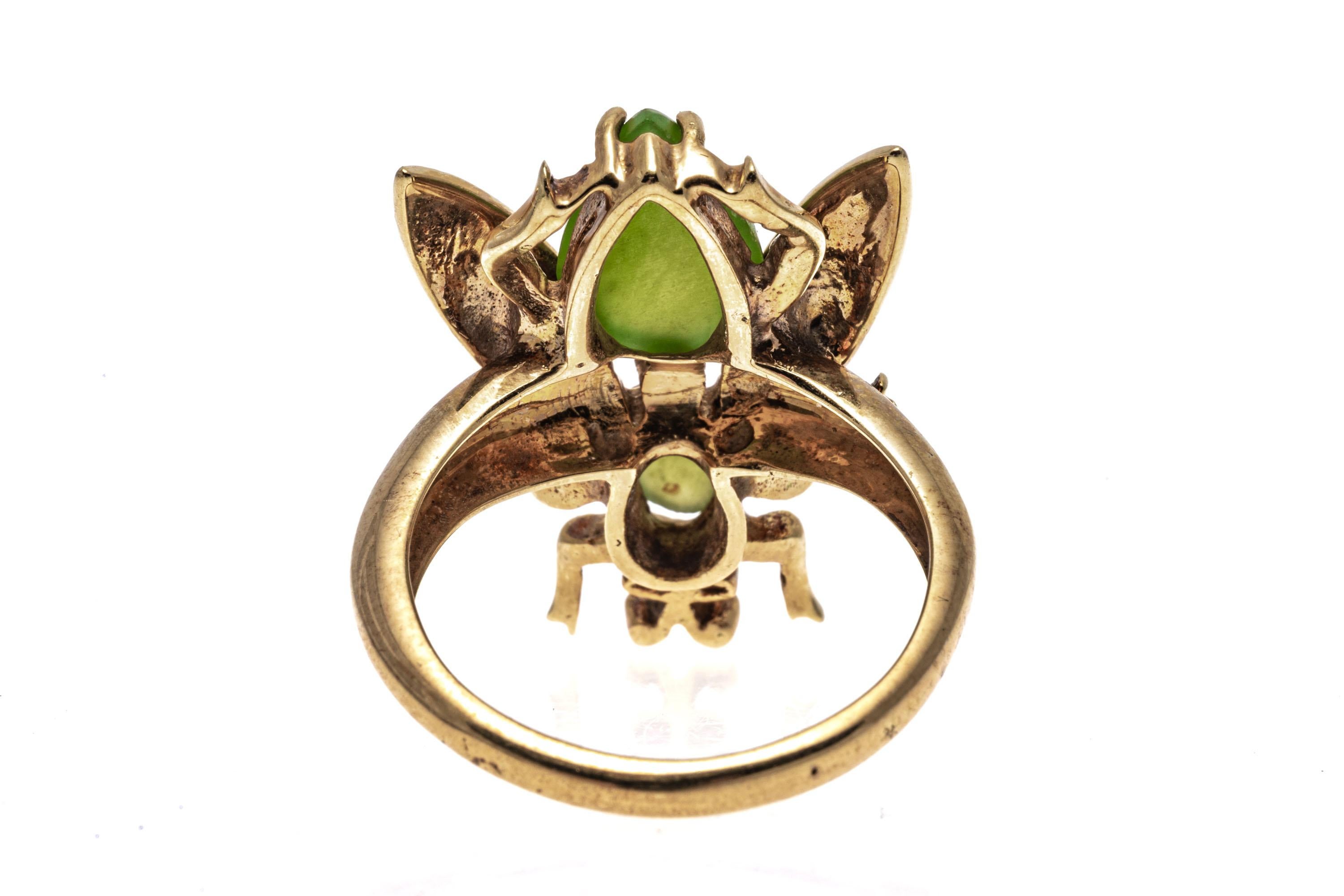 14k Yellow Gold Nephrite Jade And Ombre Enamel Bug Ring.
This striking ring is a bug motif, set with two pale green nephrite jade cabachons, one oval and one pear shaped, decorated with cobalt, turquoise and jade color ombre enamel wings. The bug is