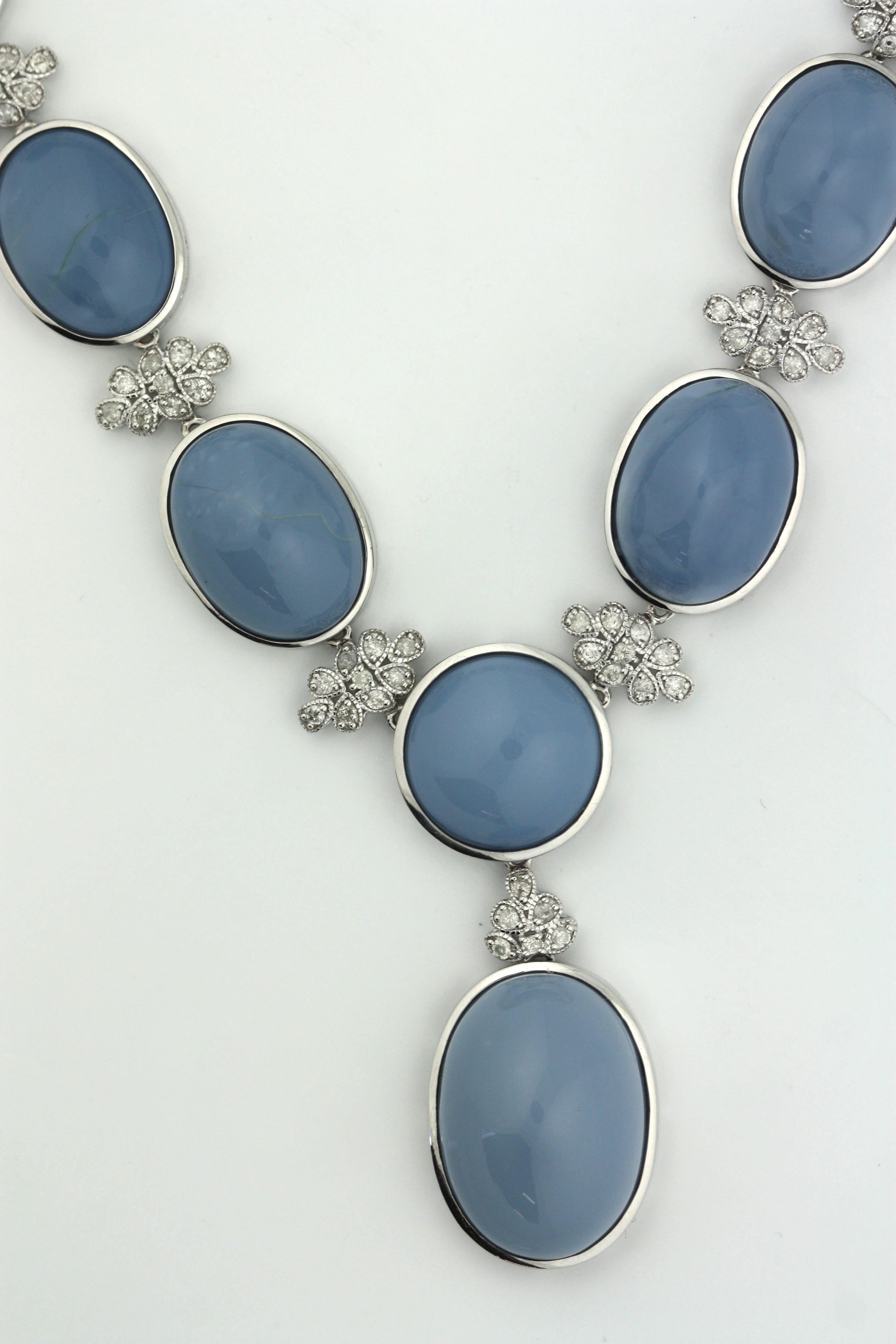 
14K Oscar Friedman Opal and Diamond Necklace 
Featuring one centered round Opal and seventeen oval cabochon-cut opals, weighing approximately 164.64 carats, accented by one-hundred seventy-four alternating diamond clusters, weighing approximately