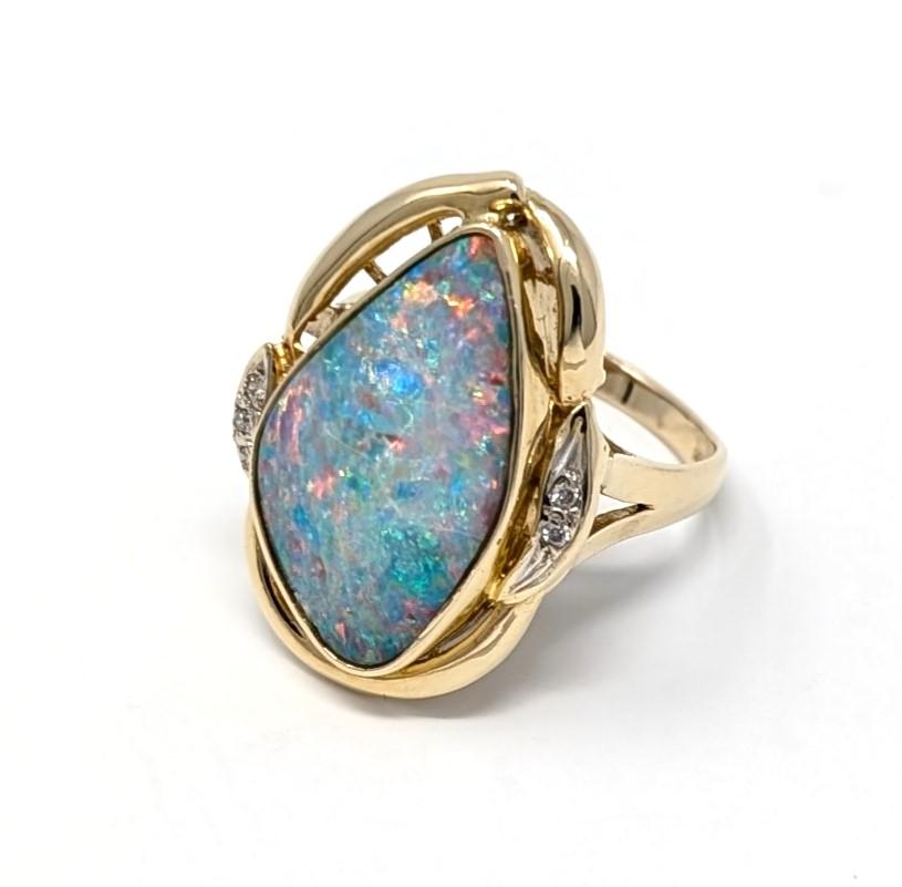 Absolutely mesmerizing large opal statement ring accented by diamonds, set in solid 14k yellow gold. Best fits a US size 9.25 finger, measures .75 inch in width by 1 inch in length and 2mm at its smallest points. Signed / hallmarked 14K 585 on the
