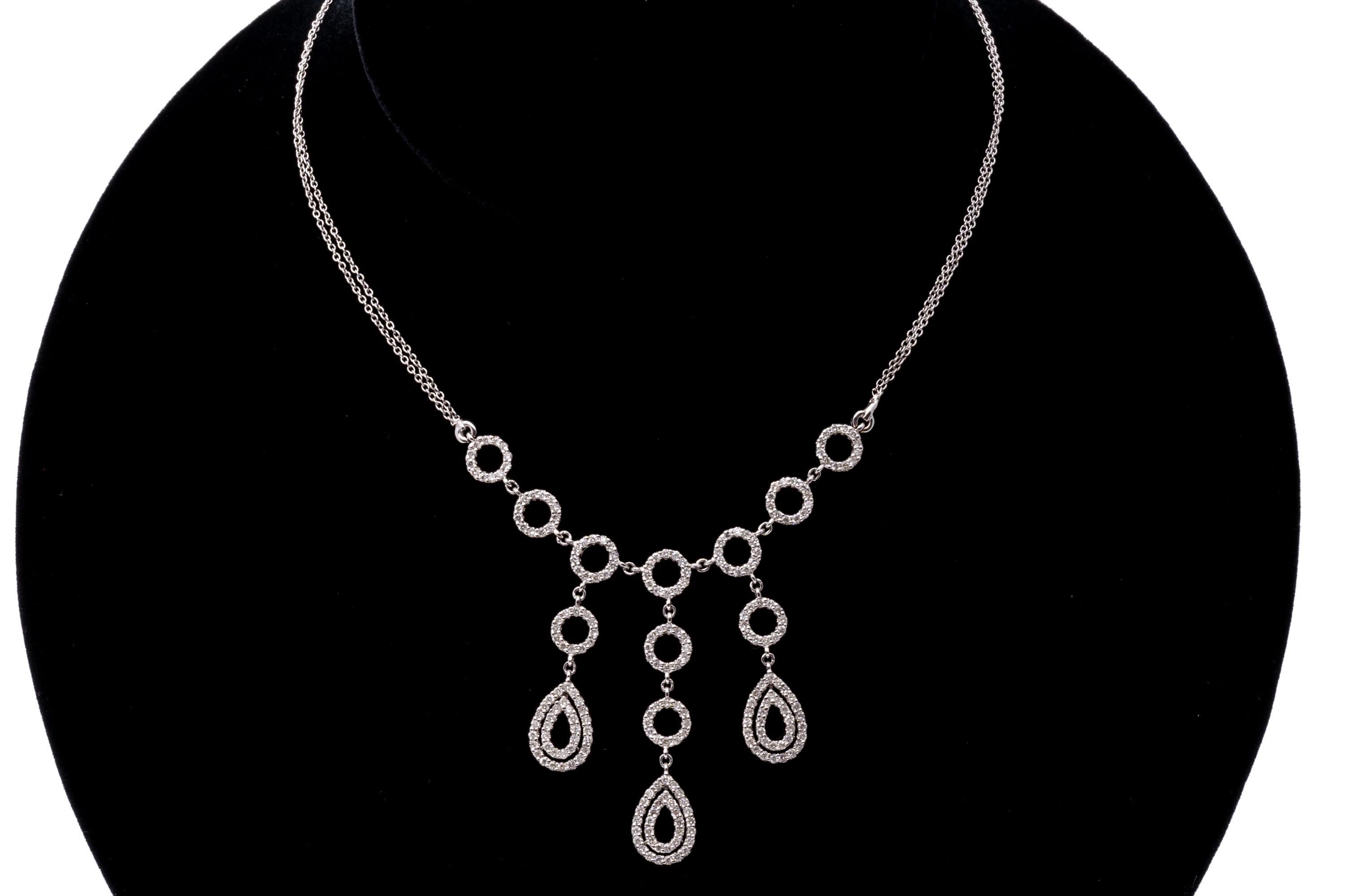 14k white gold necklace. This striking necklace contains seven open circles, set with round faceted diamonds, from which hang three drops of open circles, also set with round faceted diamonds, from which dangle open pear shaped drops, set with round