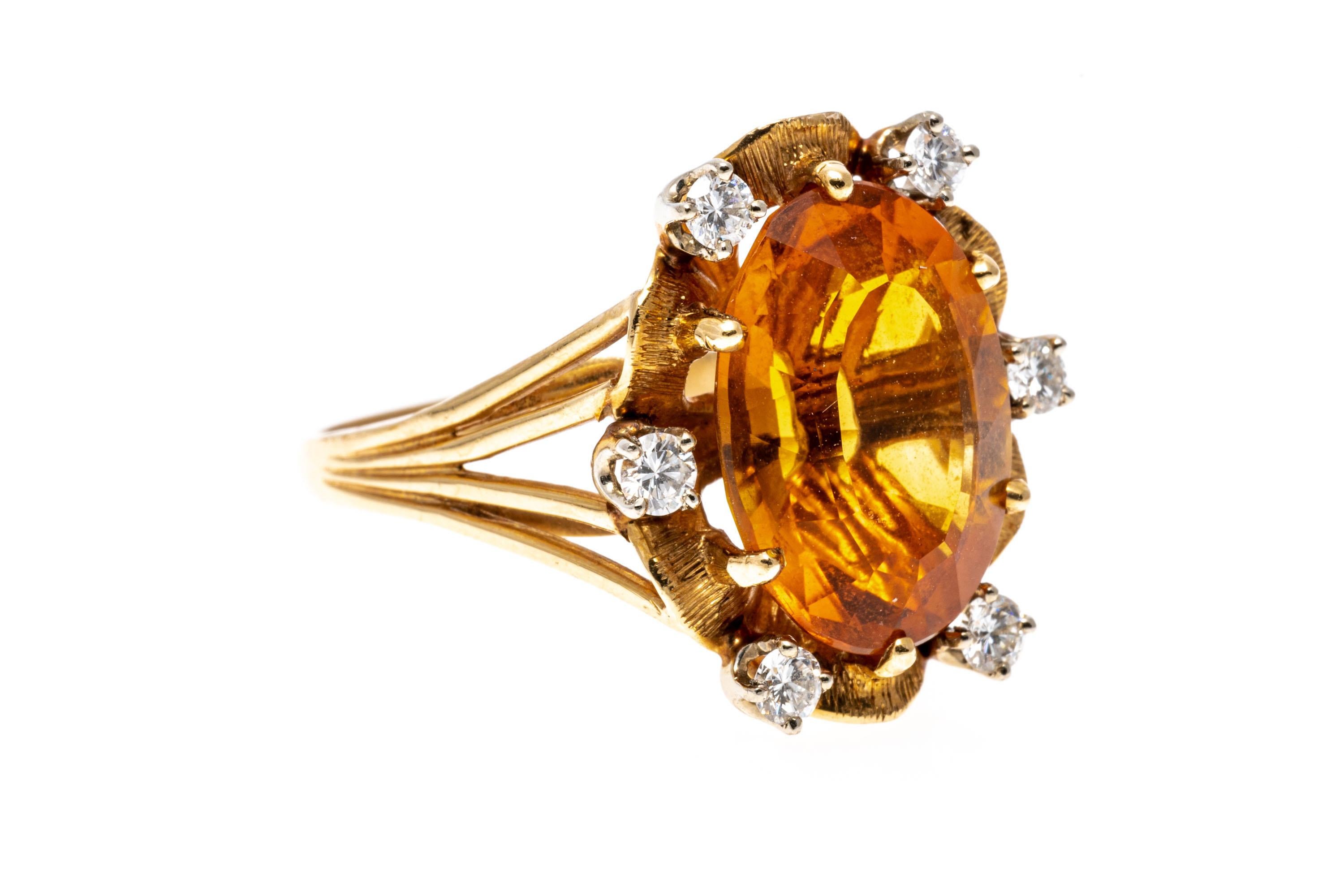 14k yellow gold ring. This gorgeous ring features a center oval faceted, medium to dark orange color citrine, approximately 5.10 CTS, accented with a florentine finished scalloped border, decorated with round brilliant cut diamonds, approximately