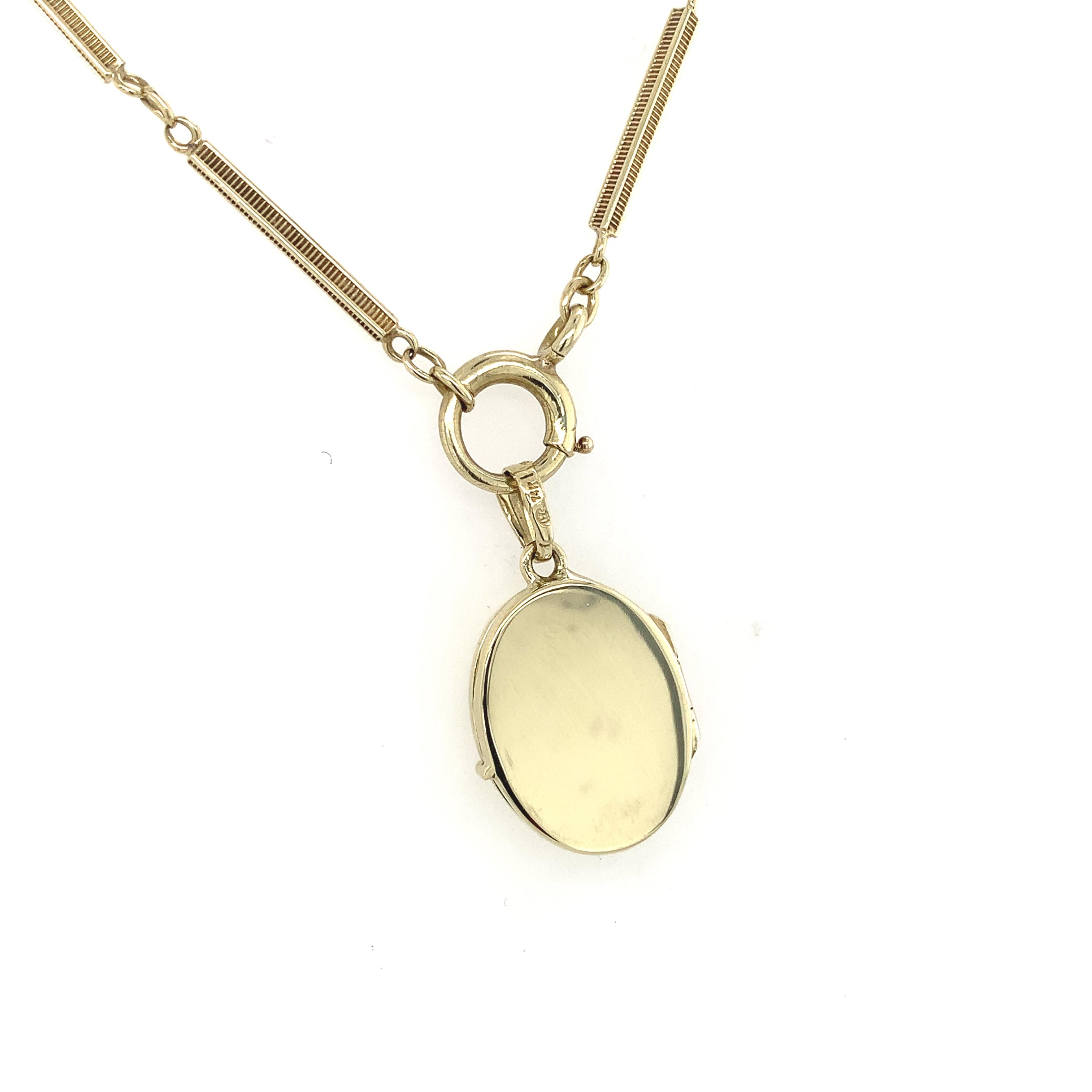 14K yellow gold oval locket with a diamond on a 14K yellow gold fancy bar link chain. The locket measures 15/16