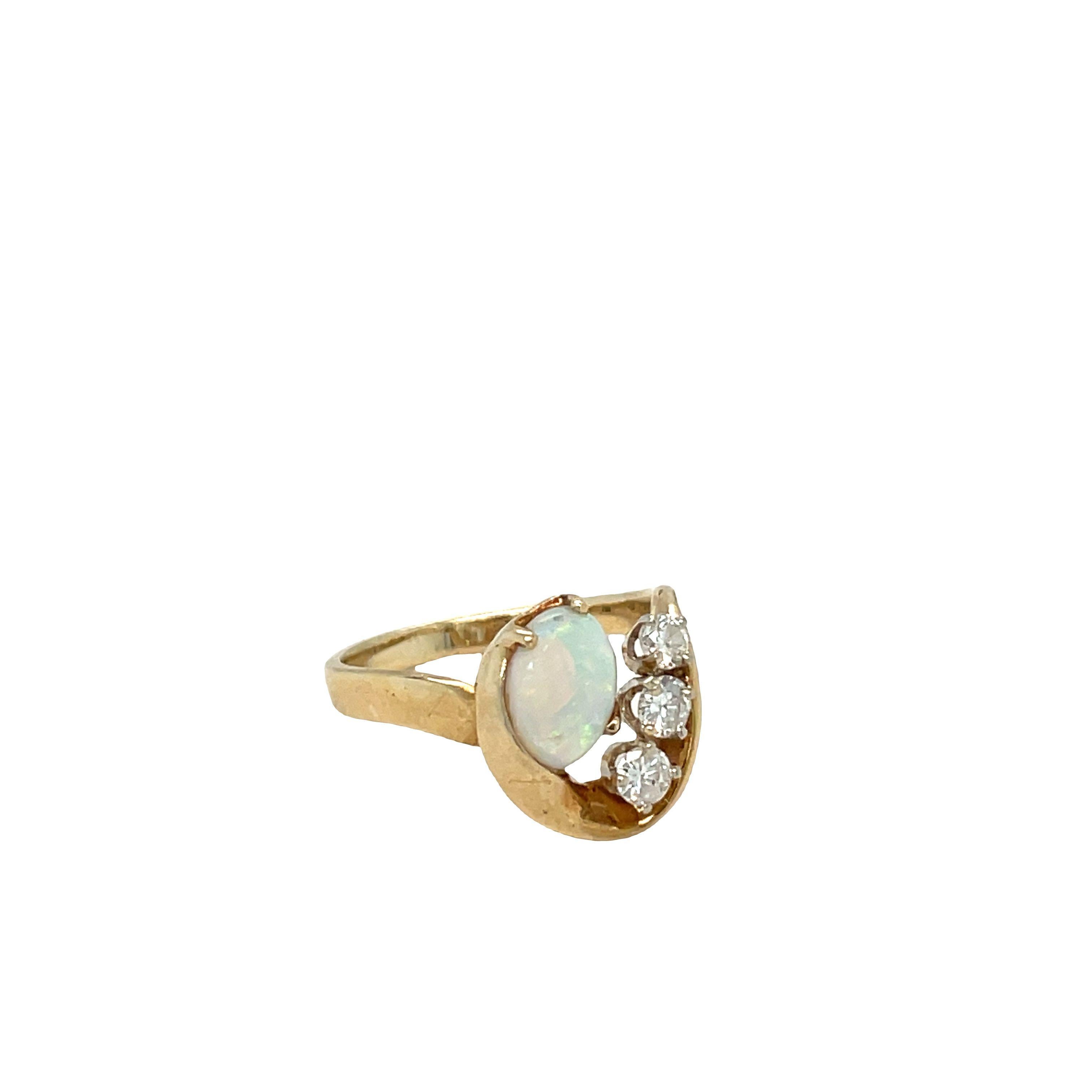 This 14k yellow gold ring is stunning with a freeform opal gemstone that will catch your eye. The opal is an oval cabochon cut, measuring 8mm x 6mm and weighs around 0.80 carat. Three round brilliant cut diamonds enhance the opal and add a total