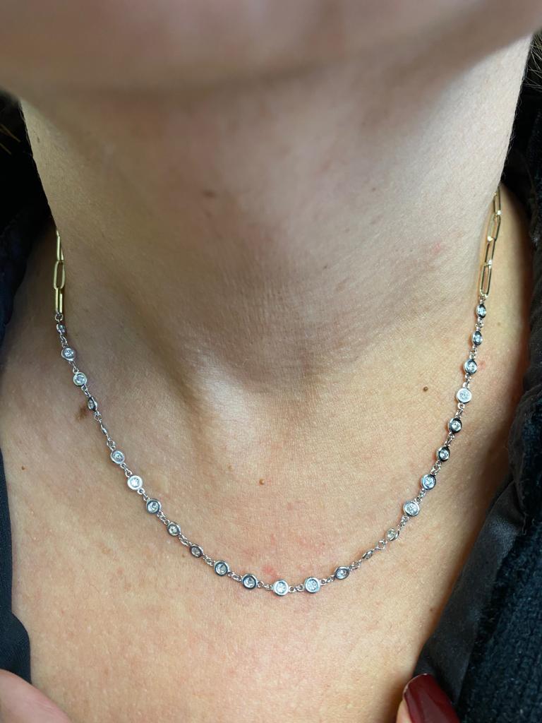 White gold by the yard diamond necklace set on a paperclip yellow chain. The necklace is set on a bezel with 0.05 carat stones. The total weight is 1.20 Carats. The color of the stones are G, the clarity is SI. The necklace is 17 inches in length.