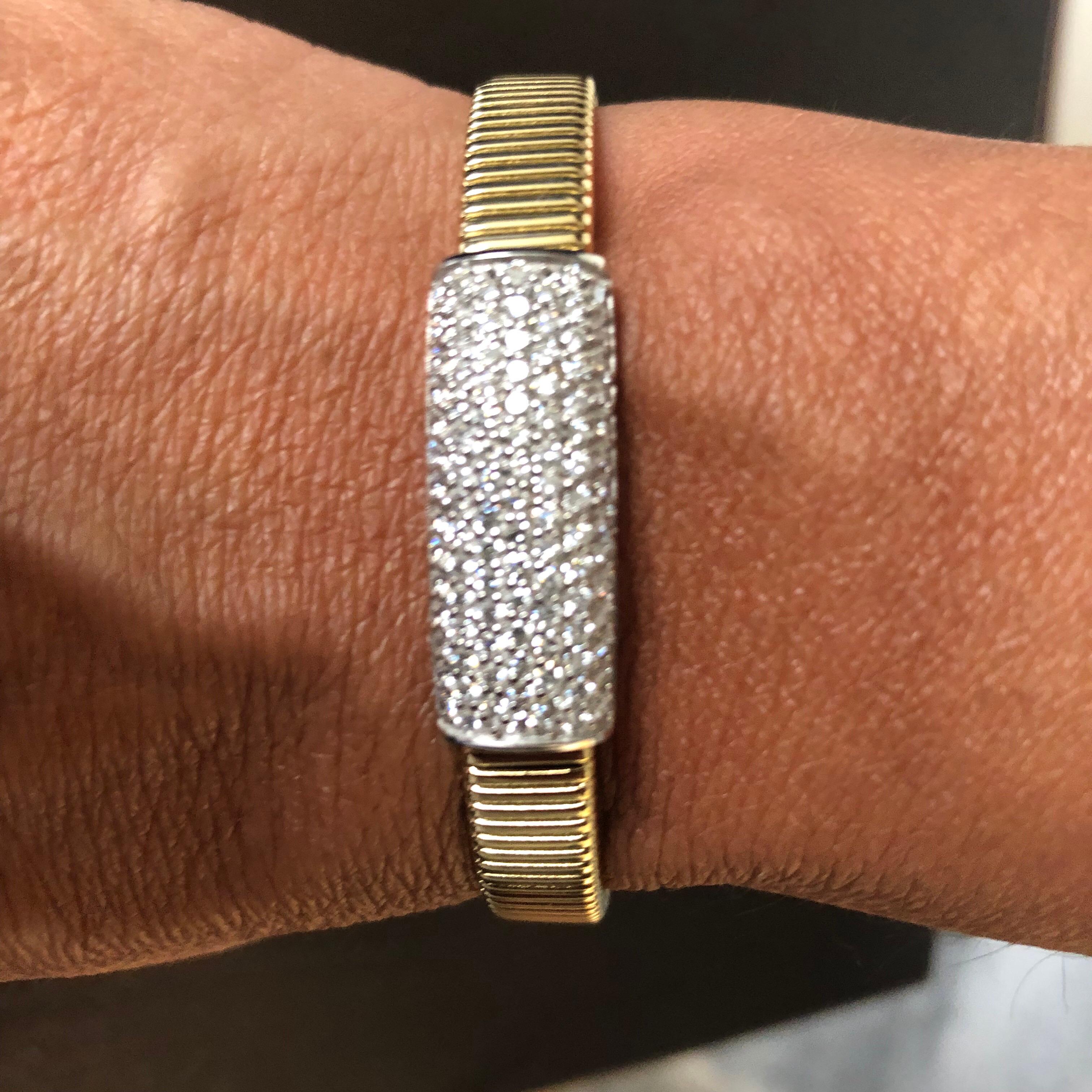 Flexible diamond Pave bangle set in 14K yellow gold. The bangle is set with 7 rows of diamonds. The total carat weight of this piece is 1.50. The color of the stones is G, the clarity is SI1-SI2. The stunning piece is manufactured in Italy.